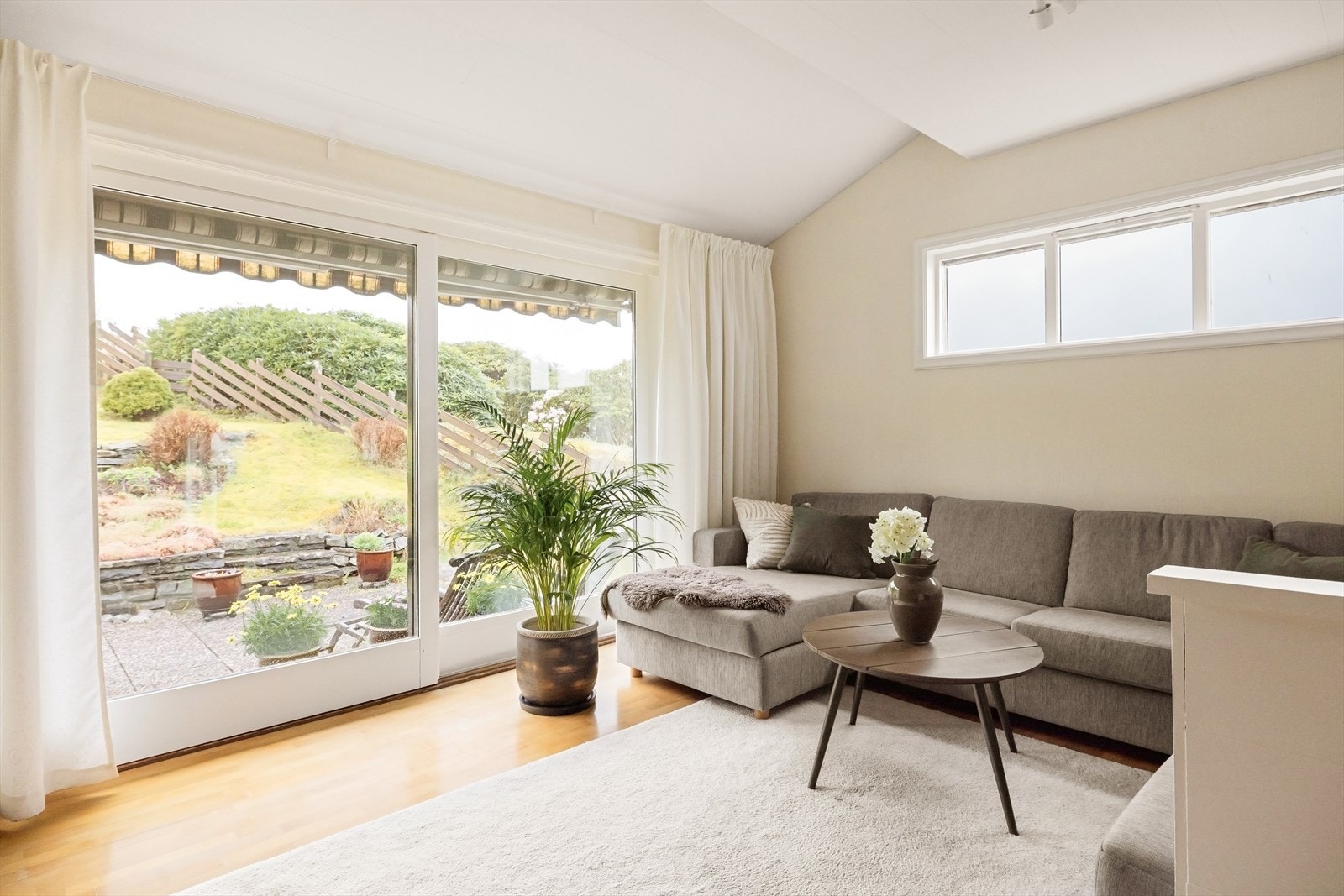 Fra stuen er det direkte utgang til en solrik terrasse og en flott opparbeidet hage med ulike soner - perfekt for å nyte lange sommerdager. Galleribilde