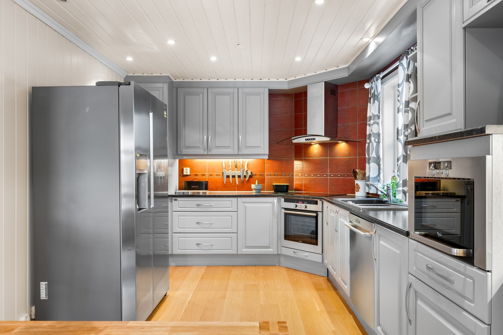 Innredningen fra 2006 har profilerte fronter som gir et klassisk og tidløst uttrykk, kombinert med laminert benkeplate og fliser på vegg over arbeidsbenken. Galleribilde