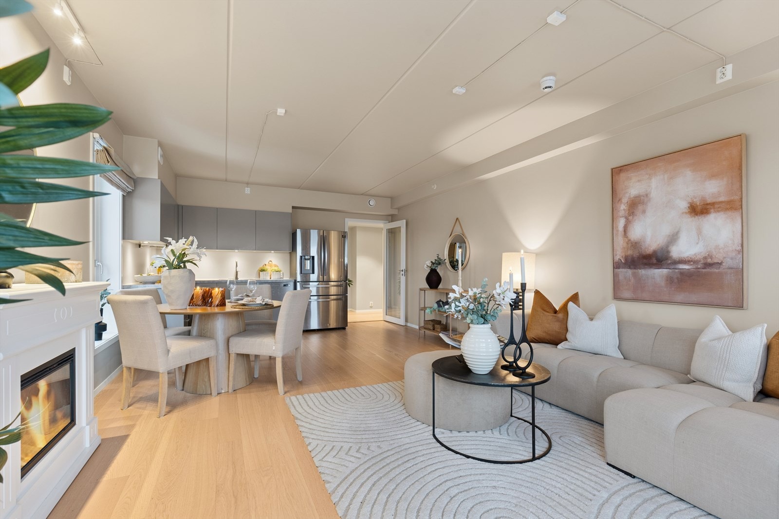 Leilighetens sosiale sone er en lys og romslig stue med åpen kjøkkenløsning. Galleribilde