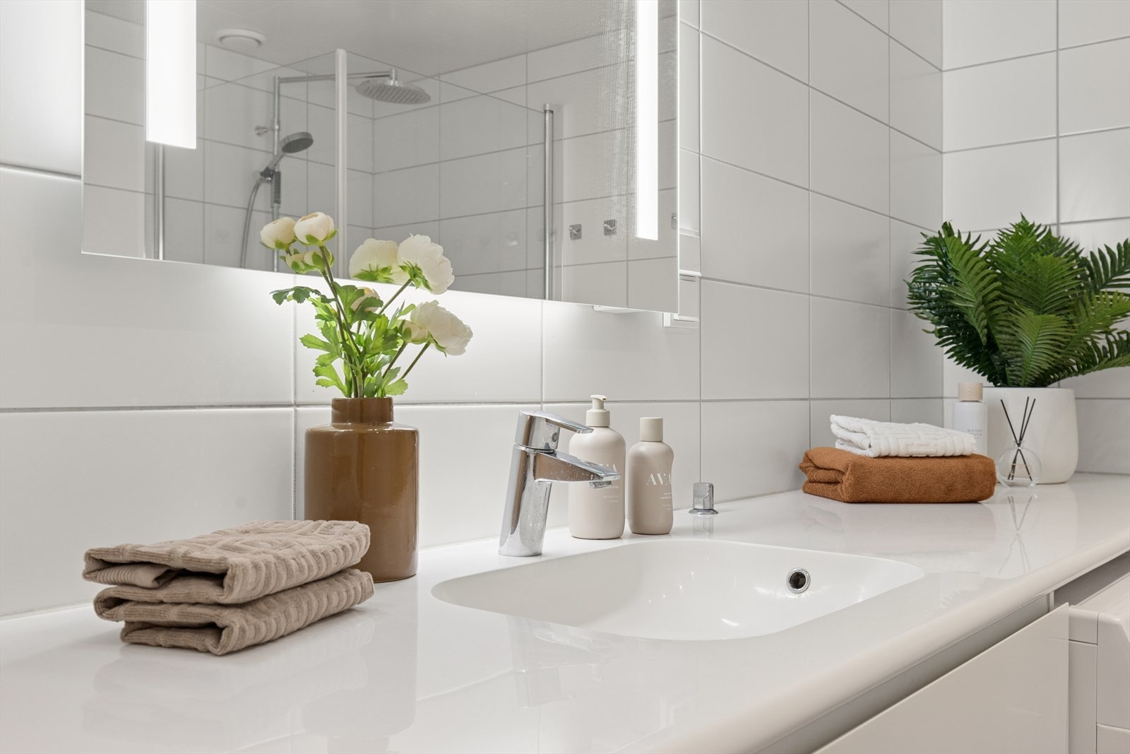 Servantskap med glatte fronter, heldekkende servant og Oras ettgrepsarmatur, i tillegg til speilskap med belysning. Galleribilde