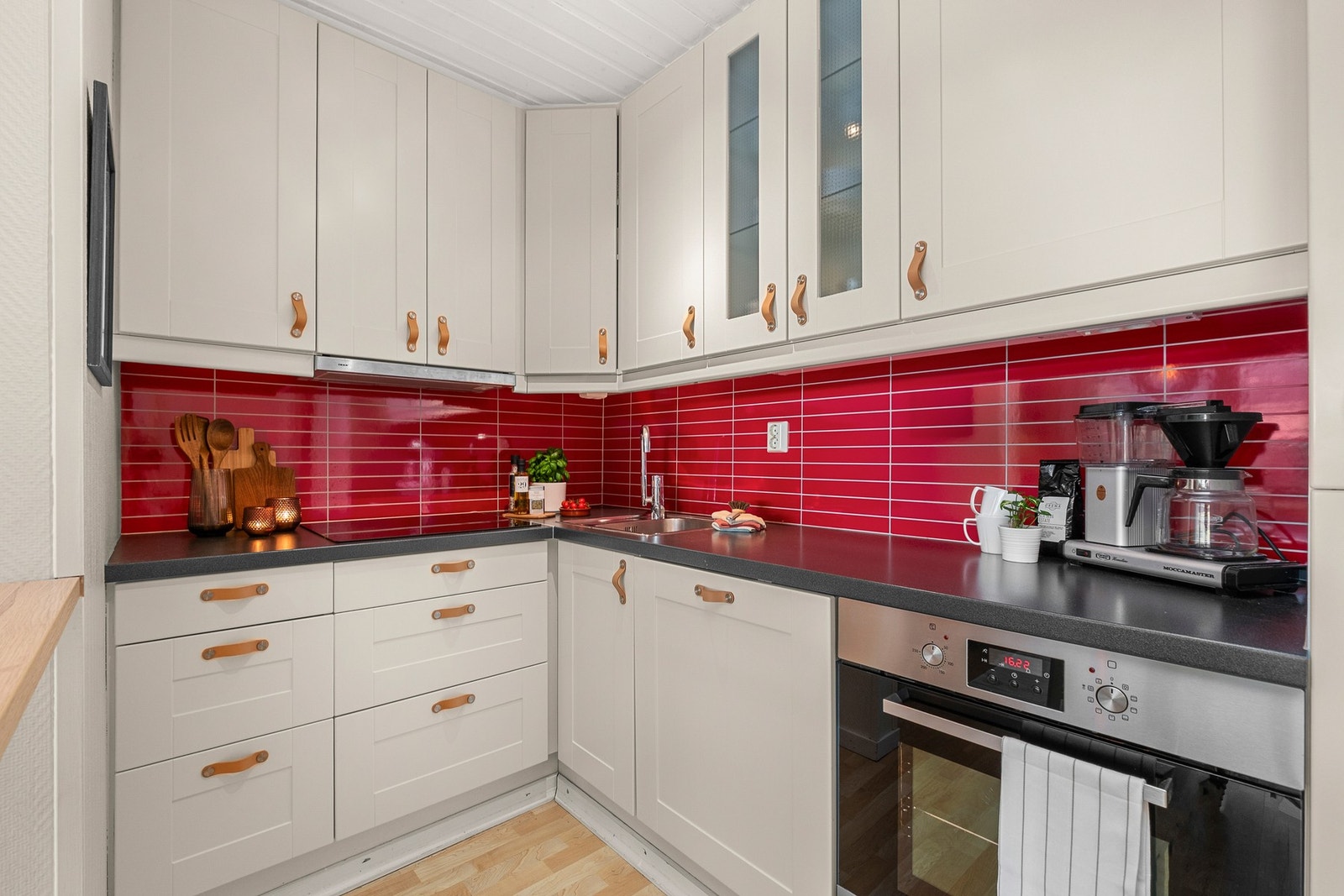 Moderne kjøkken med en praktisk hjørneløsning som gir godt med skap- og benkeplass. Galleribilde