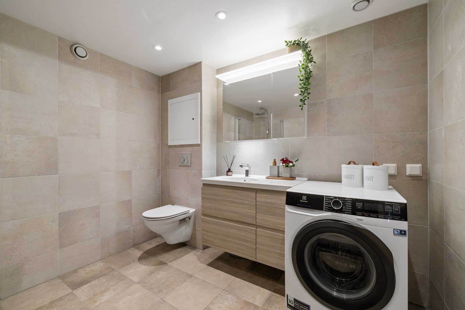 Badet på ca. 7 m² ble oppgradert i 2018 og har flislagte overflater, vegghengt toalett og opplegg for vaskemaskin. Galleribilde