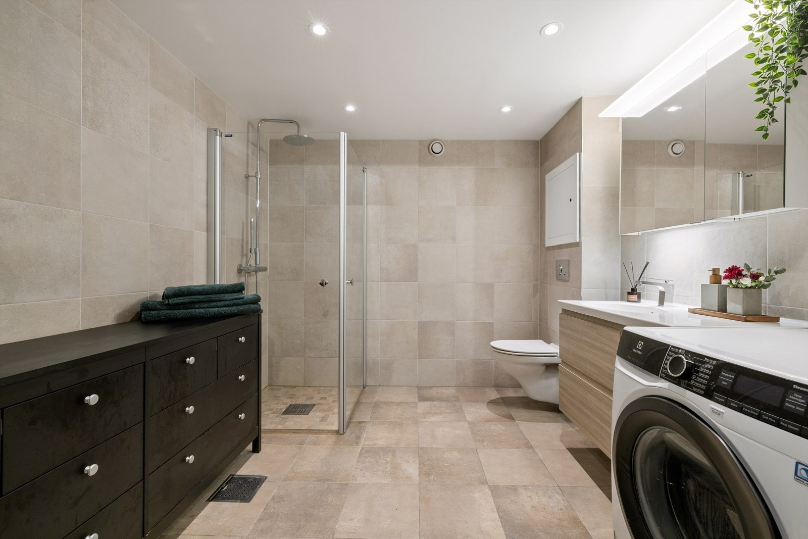 Her er det elektriske varmekabler i gulvet og et dusjhjørne med innsvingbare glassdører for optimal plassutnyttelse. Her er det også god plass til badekar om ønskelig. Galleribilde