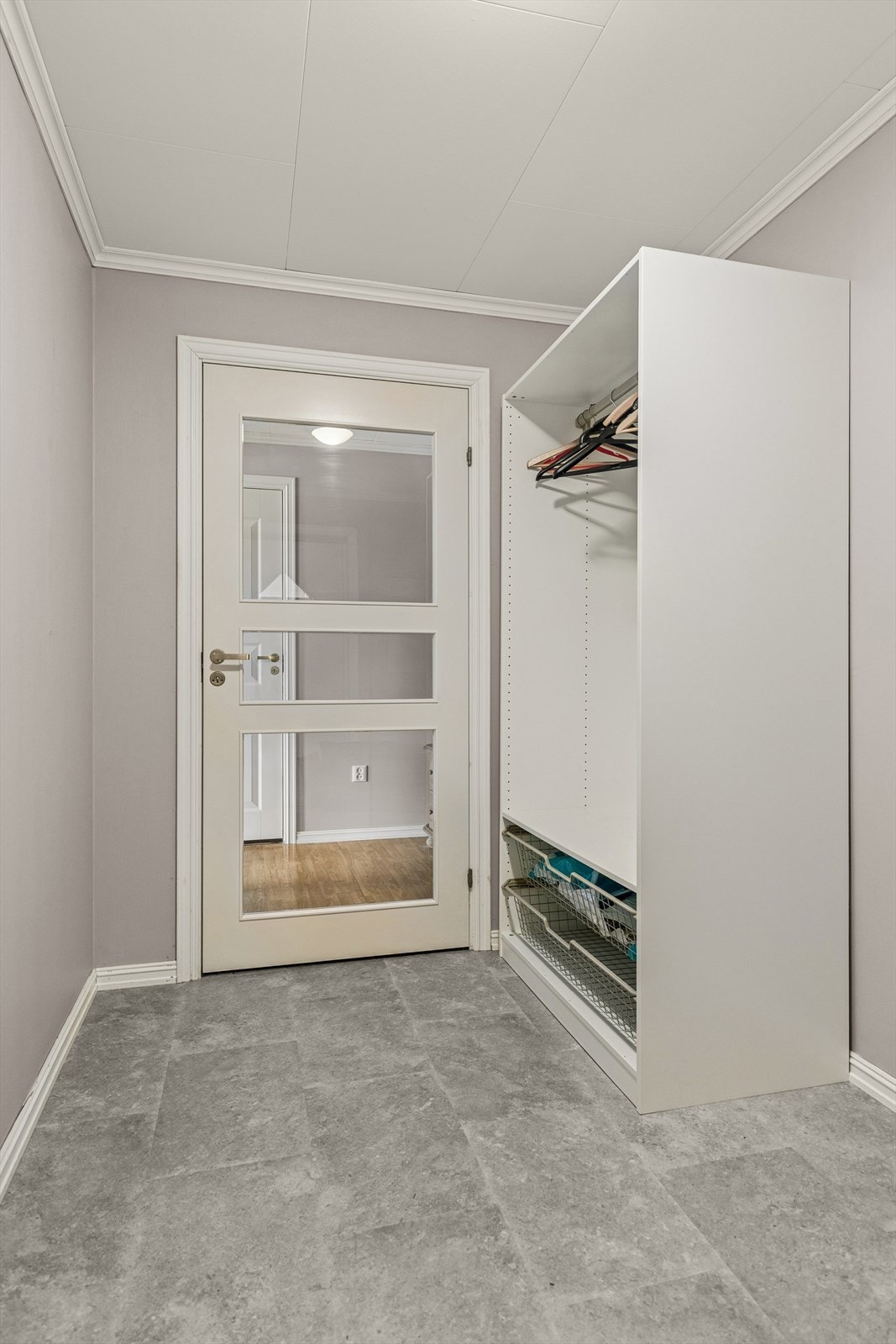 Entréen har god plass til både oppheng av yttertøy og plassering av sko. Her er det plass til å etablere ytterligere oppbevaring. En profilert dør med glassfelt slipper lyset videre inn i boligen. Galleribilde