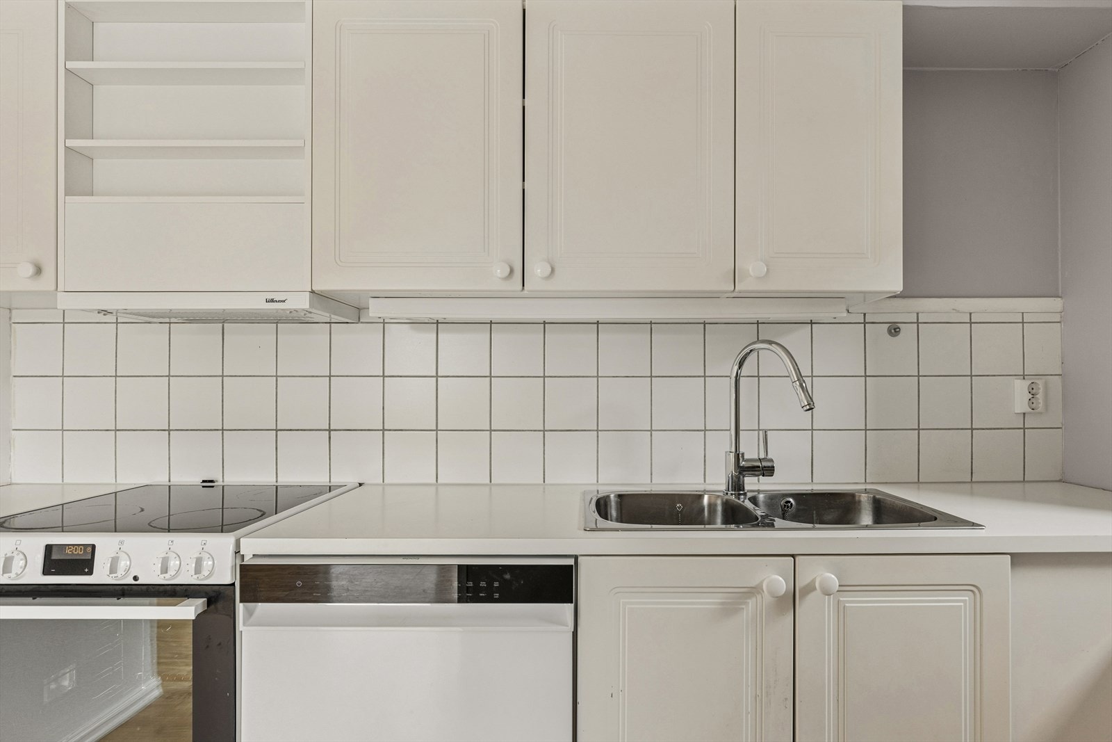 Fliser over benkeplaten beskytter veggen og forenkler renholdet. Kjøkkenventilator med avtrekk rett ut. Galleribilde