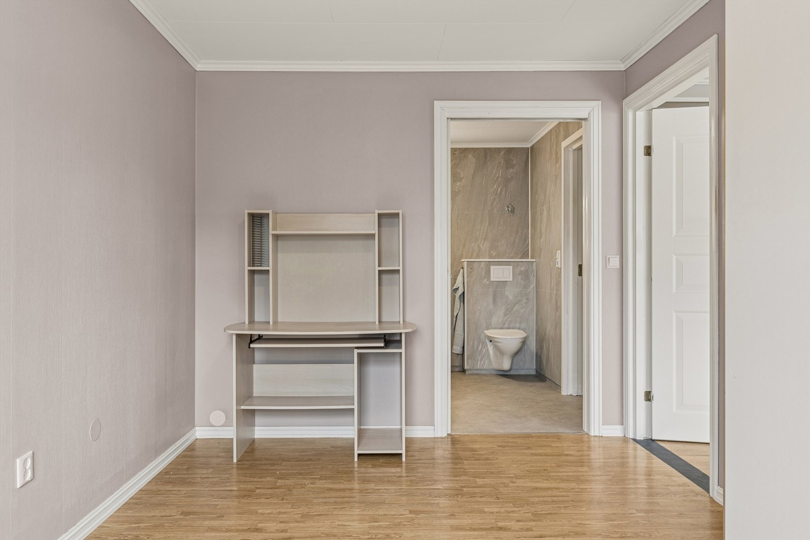 Videre kommer du inn i en mellomgang som på en naturlig måte fordeler leilighetens rom. Herfra er det blant annet tilkomst til det kombinerte badet og vaskerommet, som er både funksjonelt og moderne. Galleribilde