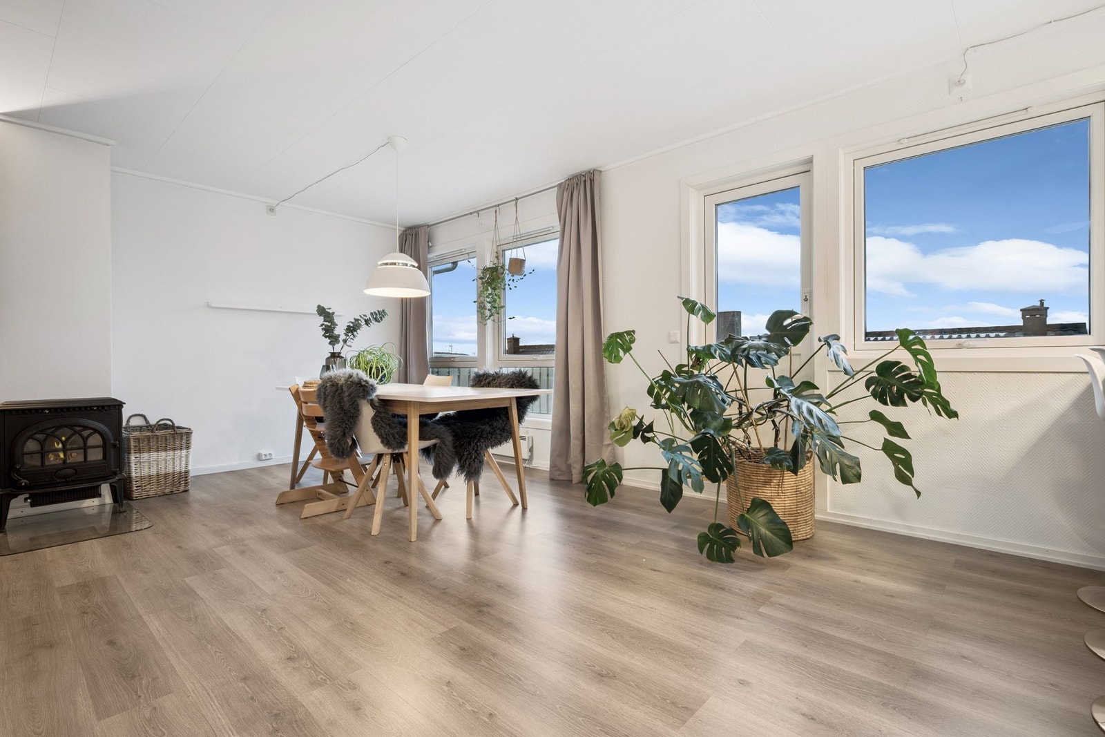 Det e god plass til et romslig spisebord mellom stue og kjøkken. Legg merke til at rommet har store vinduer og gjennomgående lys gjør rommet ekstra trivelig Galleribilde