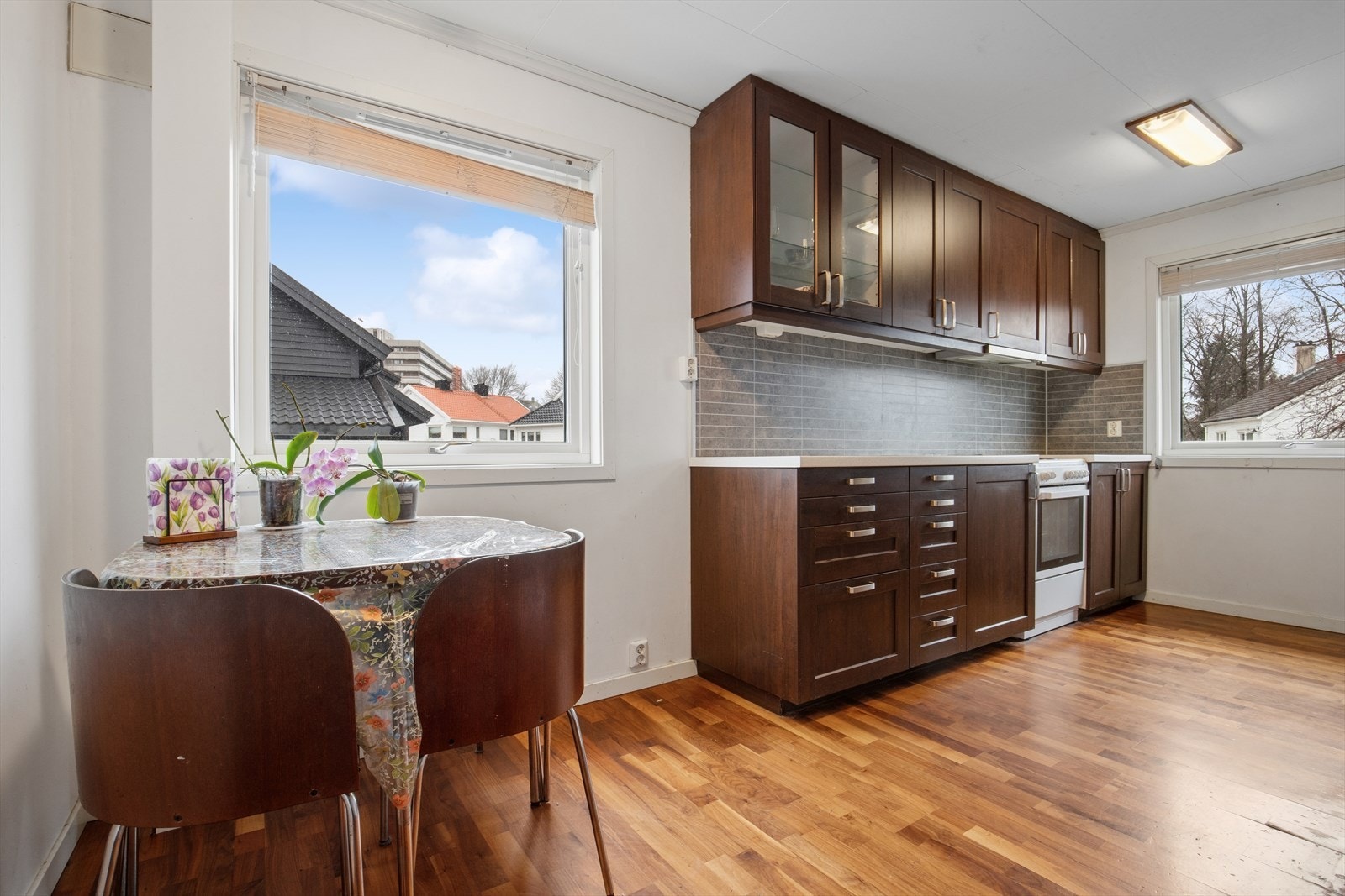 Boligens kjøkken har parkett på gulv og malte plater på vegger. Innredning med profilerte fronter og benkeplate i laminat utførelse Galleribilde