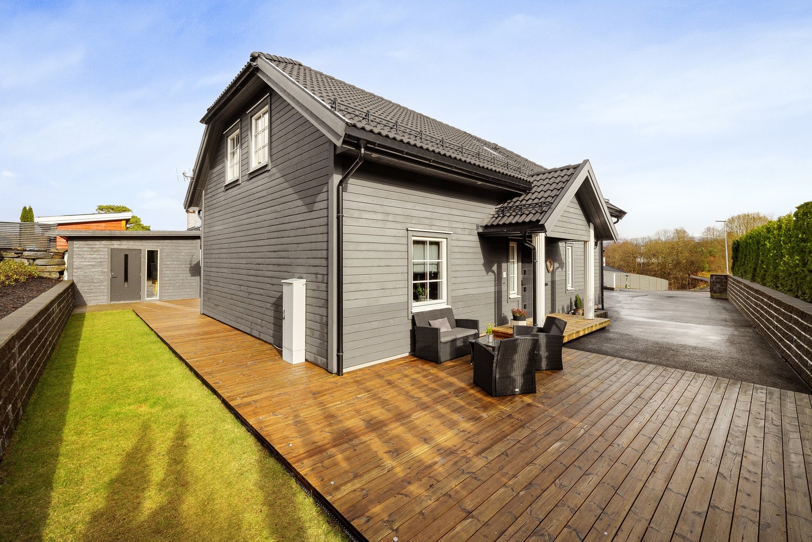 Pent opparbeidet tomt med gressplen, platting og asfaltert gårdsplass Galleribilde