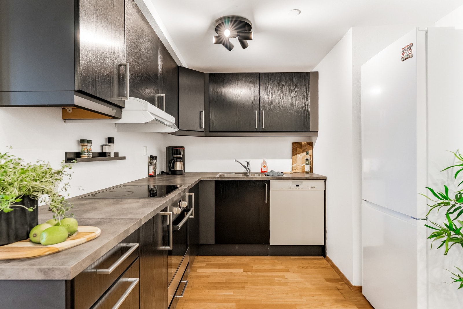 Innredning med glatte fronter og benkeplate av laminat. Integrert stekeovn og platetopp. Galleribilde