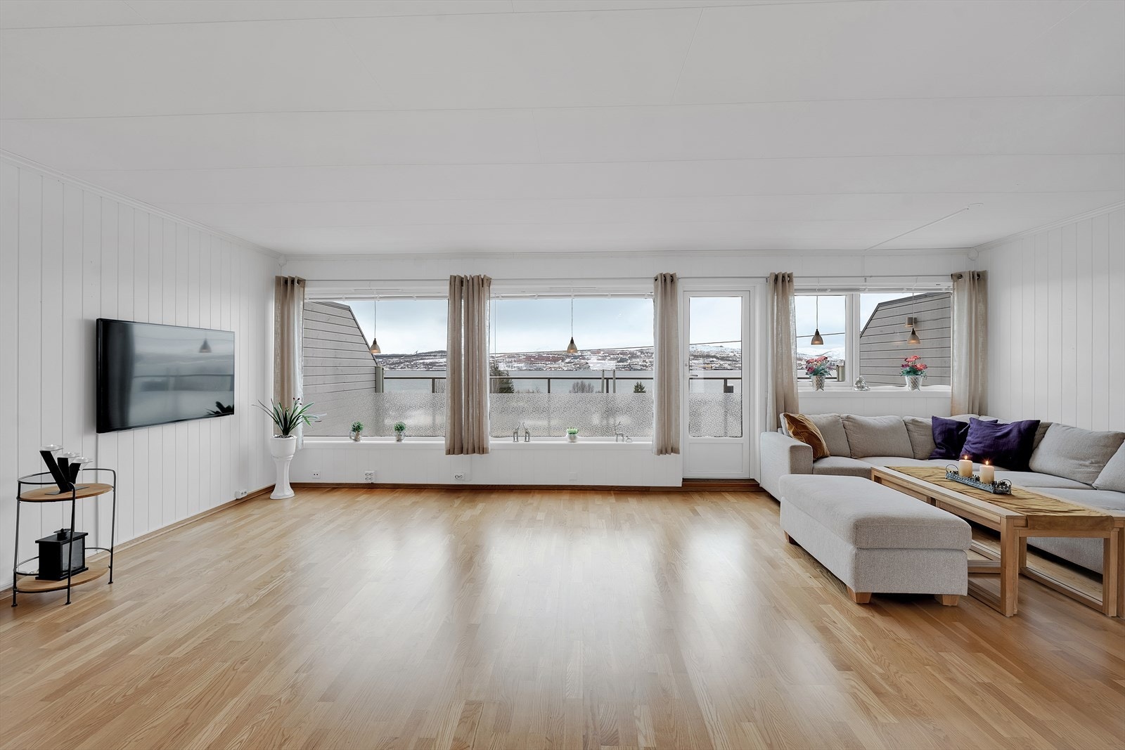 Stuen fylles av naturlig dagslys fra store vindusflater, som sikrer en innbydende og trivelig stemning i boligen. Galleribilde