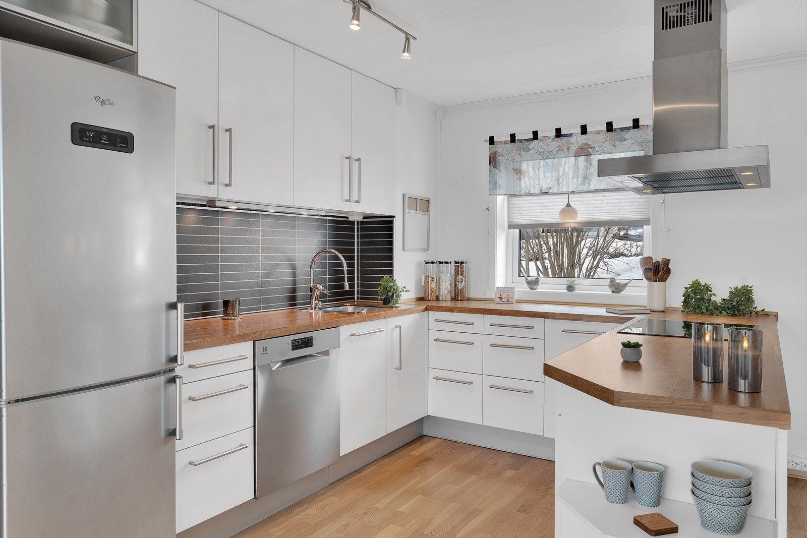 Pent og lyst, U-formet kjøkken, med rikelig skap- og benkeplass. Galleribilde