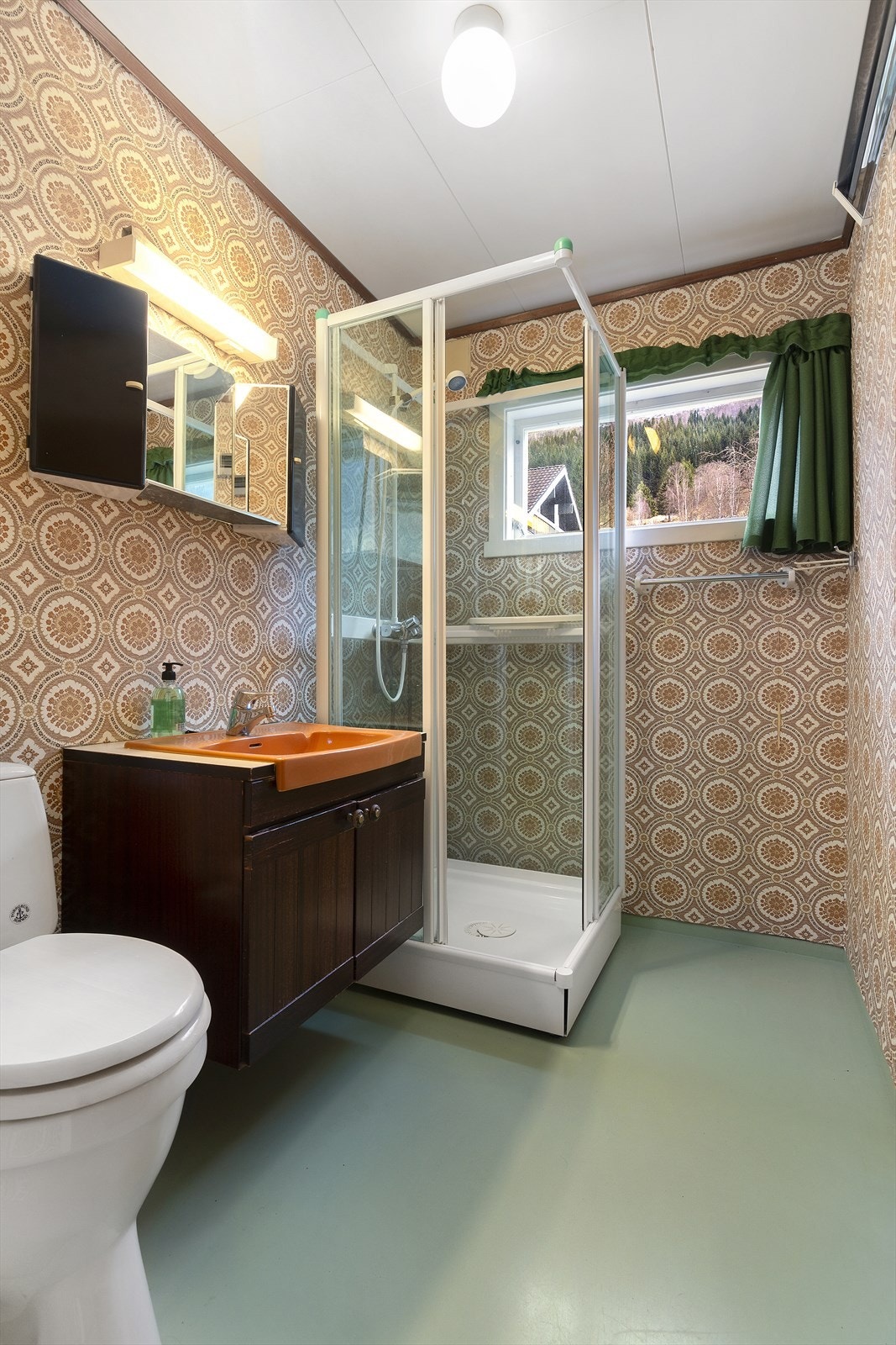 Det andre badet i hovedetasjen har baderomsinnredning, toalett og dusjkabinett. Rommet gir en skikkelig retrofølelse. Galleribilde