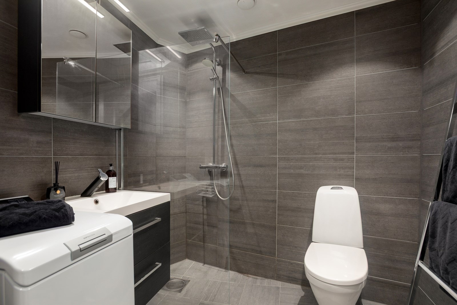 Dusj med fast felt i herdet glass, servant, gulvstående klosett. Galleribilde