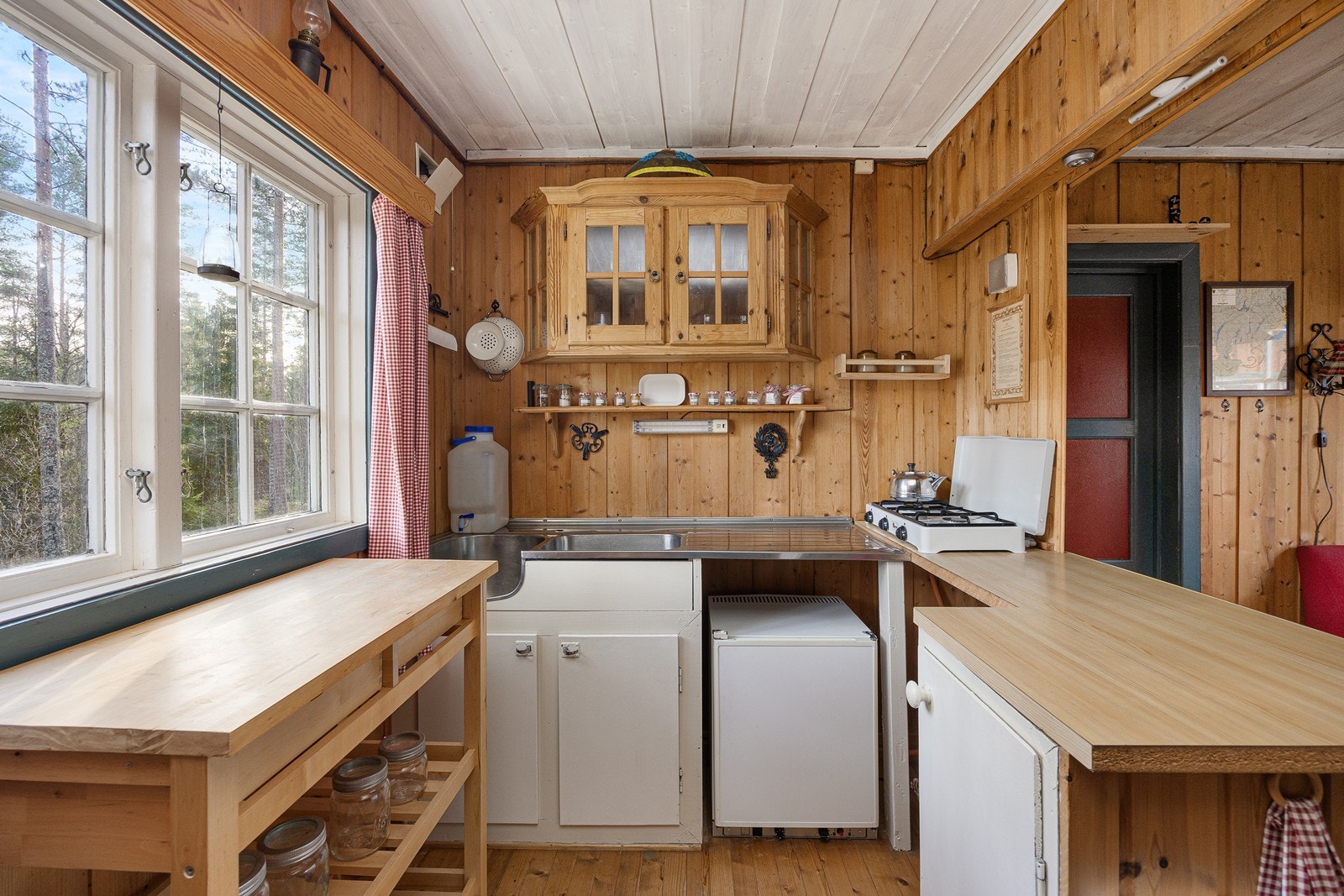 Det er ikke vann eller avløp i hytta, og avløpet fra oppvaskkummen går til en bøtte i benkeskapet. Galleribilde