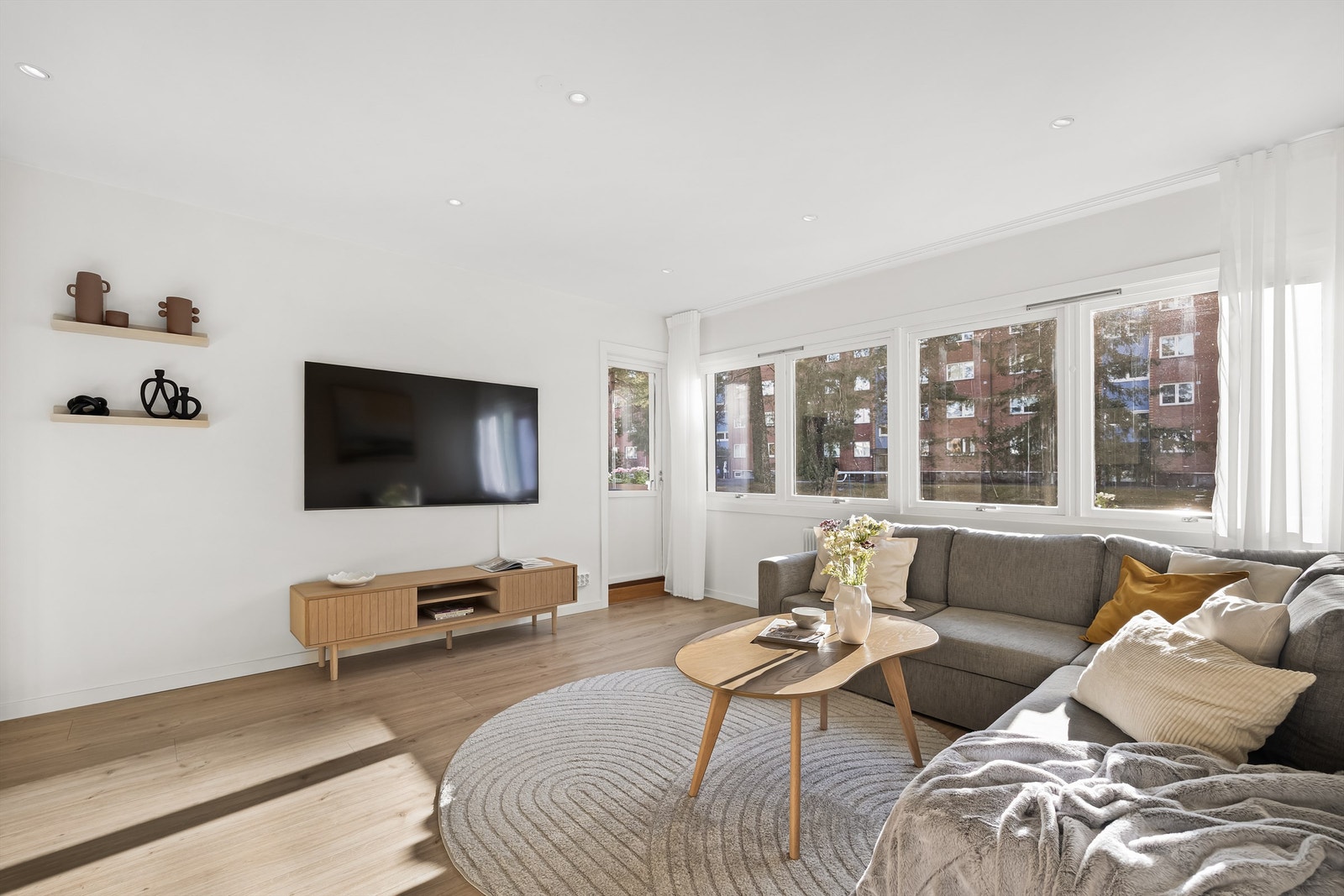 Pen stue med store vindusflater som slipper inn godt med lys og bringer inn den koselige utsikten mot grøntområder og skogen Galleribilde