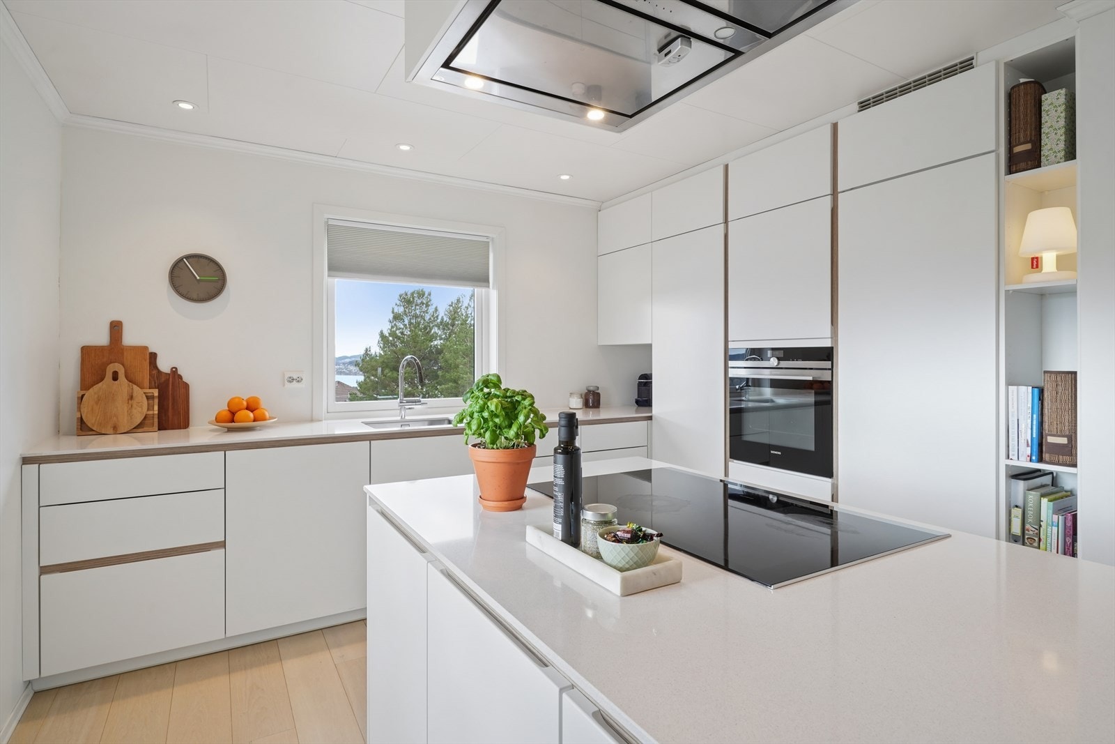 Stilren innredning med hvite, glatte fronter og en slitesterk benkeplate i kvartskompositt. Galleribilde