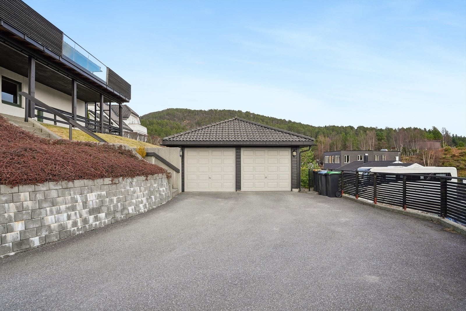 Asfaltert gårdsplass med god plass til parkering foran garasjen. Galleribilde