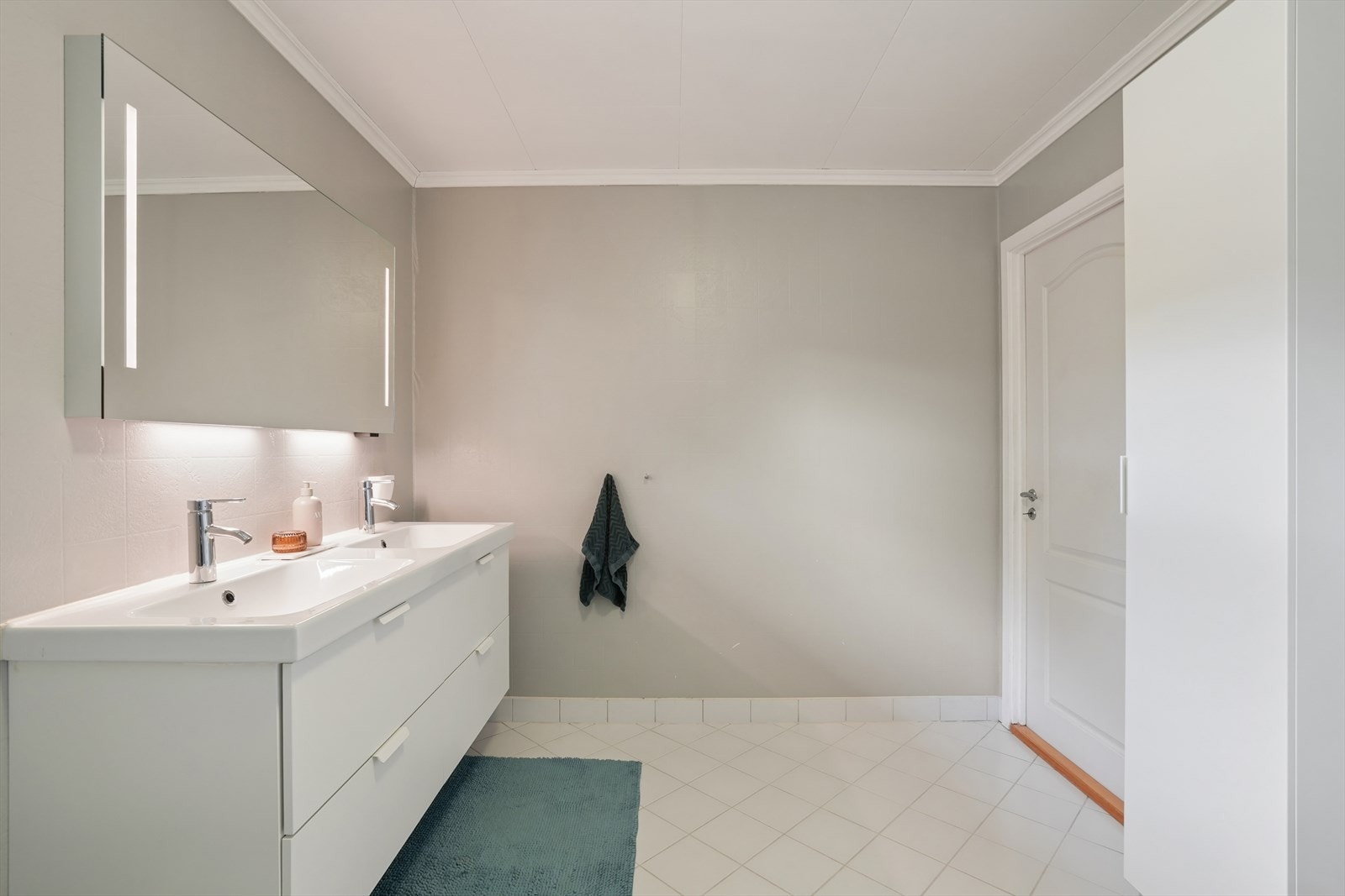 Badet i første etasje med en dobbel servantinnredning og speil med integrert lys. Galleribilde