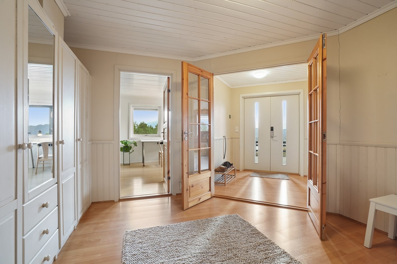 Fra hallen i underetasjen fører doble glassdører inn til et innredet rom og trappen opp til hovedetasjen. Velkommen inn! Galleribilde