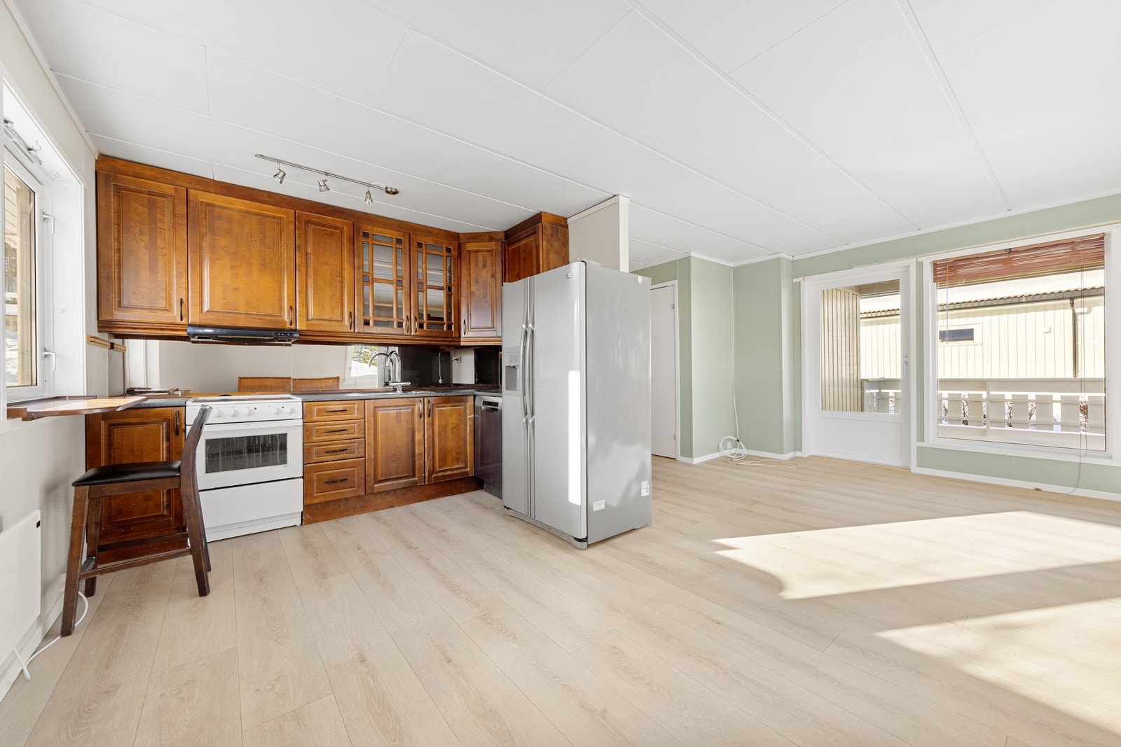 Kjøkkenet er utstyrt med heltre profilerte fronter, laminat benkeplate og speil mellom benk og overskap. Galleribilde