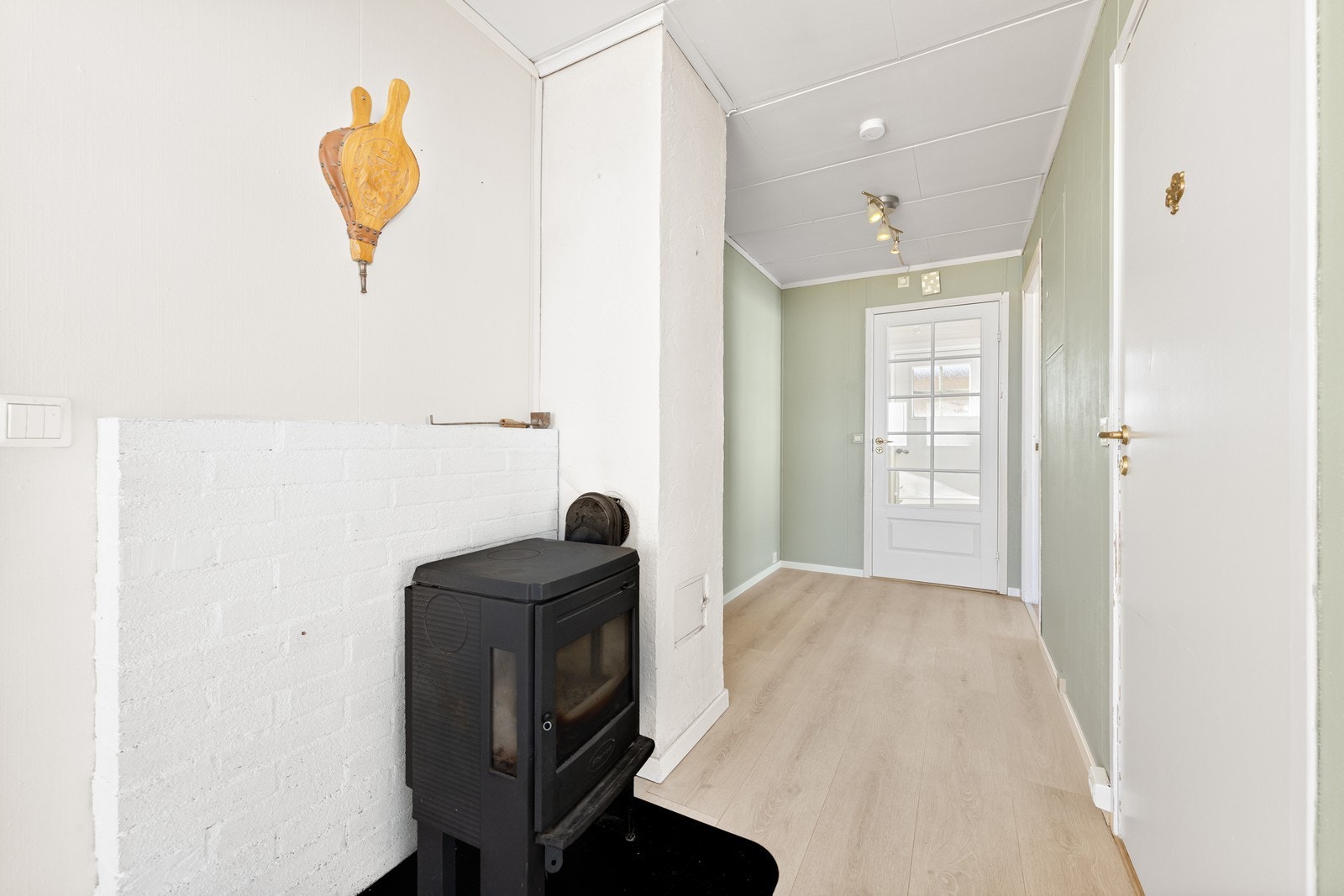 Boligen varmes opp med strøm og ved, og i gang inn mot stue er det installert en vedovn. Galleribilde