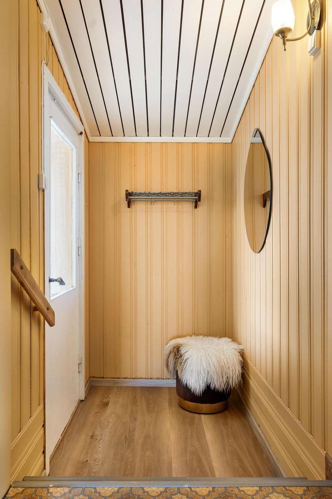 Velkommen inn. Entréen har laminatgulv og panel på veggene. Galleribilde