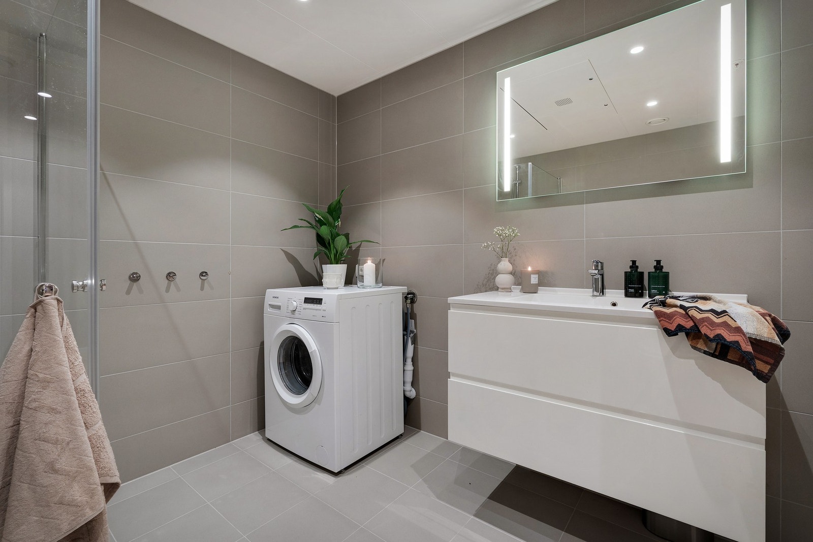 - Badet fremstår lyst og delikat med flislagte vegger og gulv, gulvvarme og moderne innredning - Galleribilde