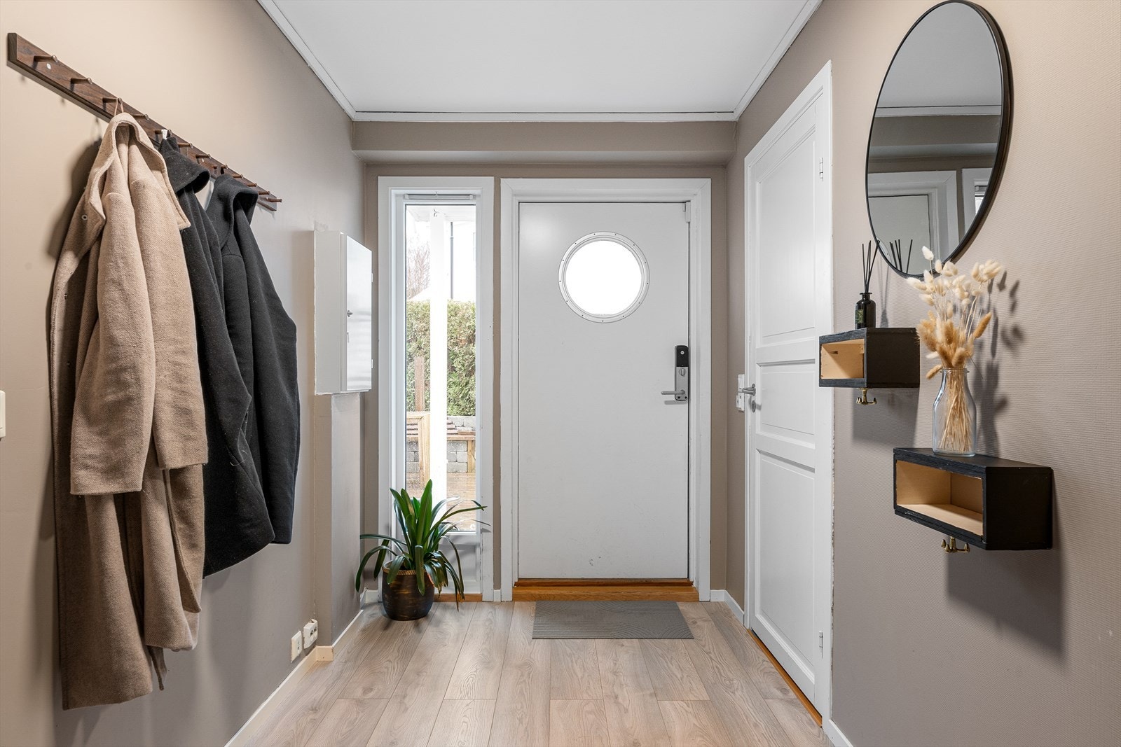 Velkommen inn. Entréen gir et godt førsteinntrykk og leder videre inn i boligens sosiale sone. Galleribilde