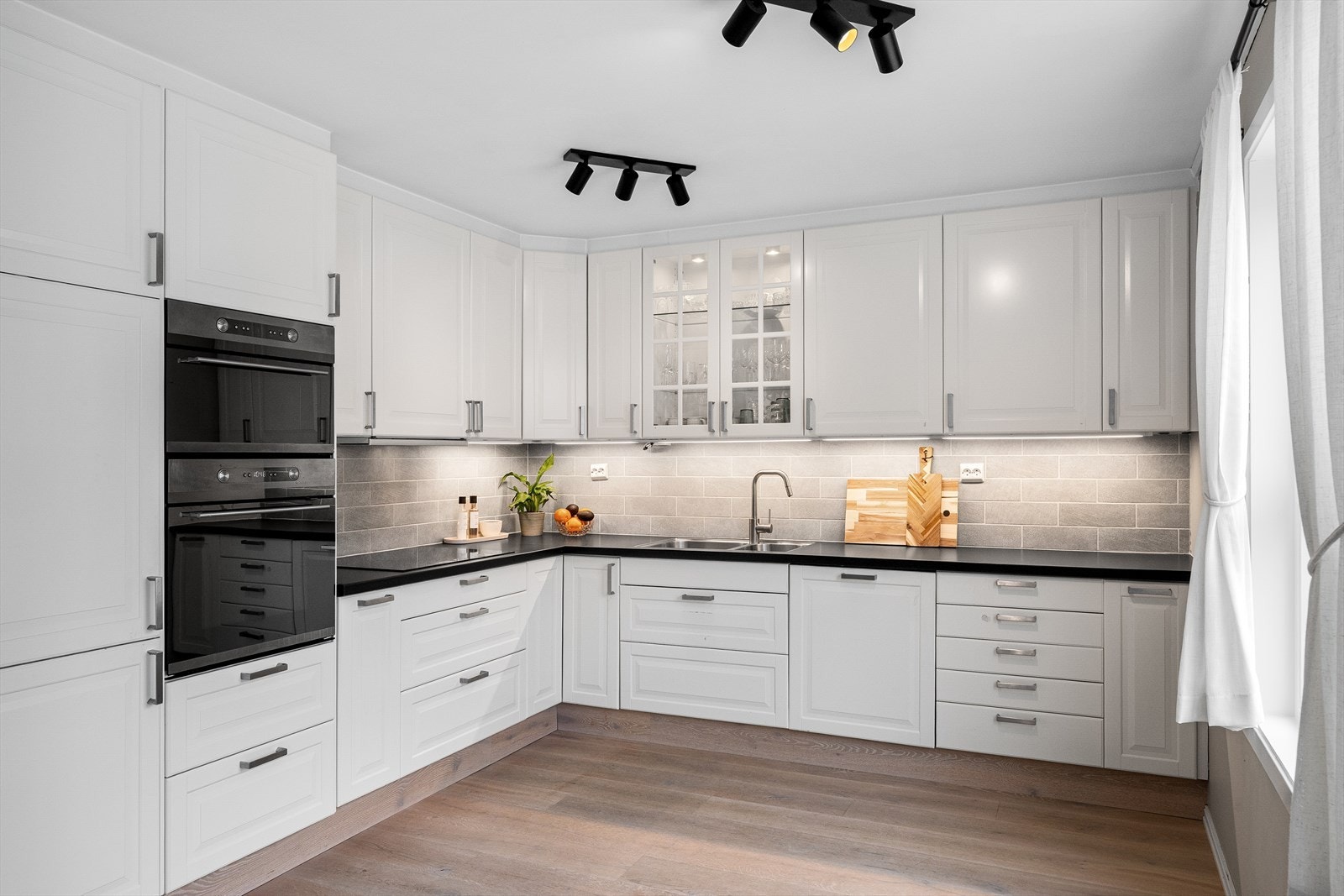 Kjøkkenet fra 2012 har en tidløs innredning med profilerte fronter og integrerte hvitevarer. Galleribilde