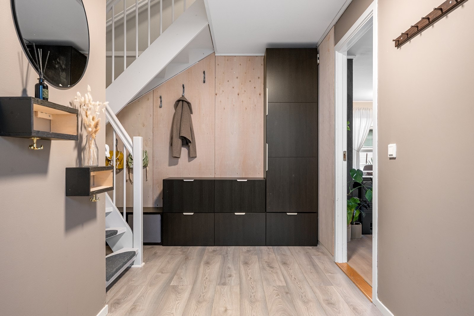Praktisk garderobeløsning i gangen gir god plass til oppbevaring av yttertøy. Trappen fører opp til andre etasje. Galleribilde