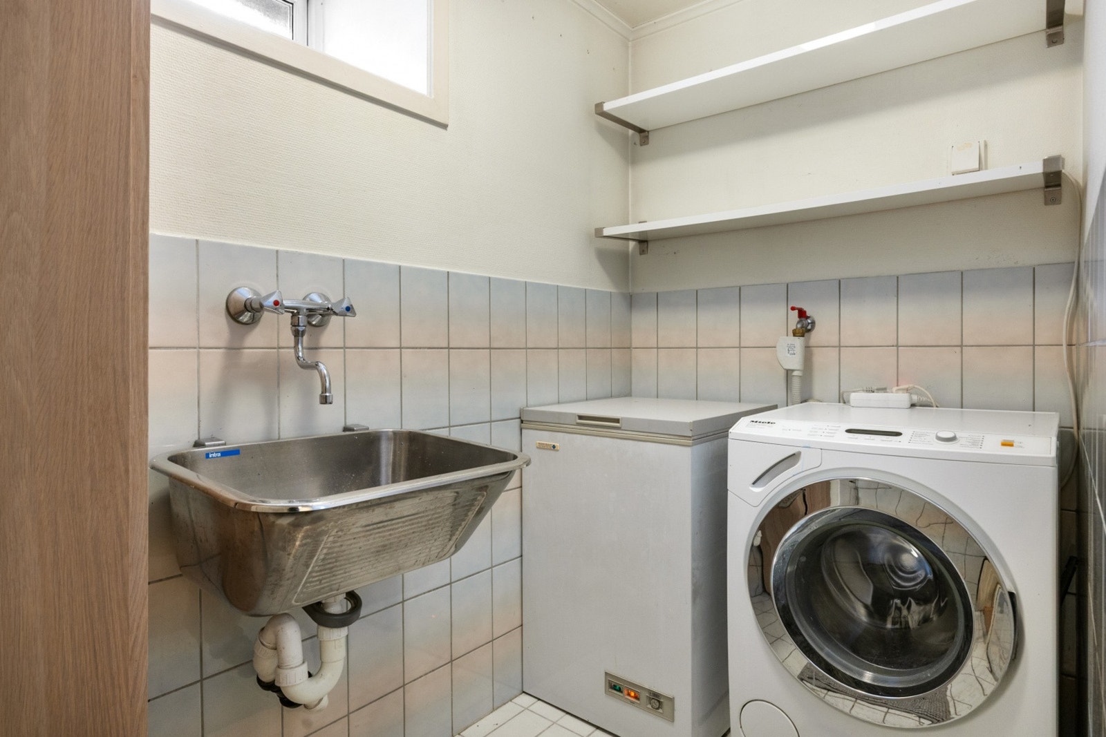 Praktisk og flislagt vaskerom. Fryser og Miele vaskemaskin medfølger handelen. Galleribilde