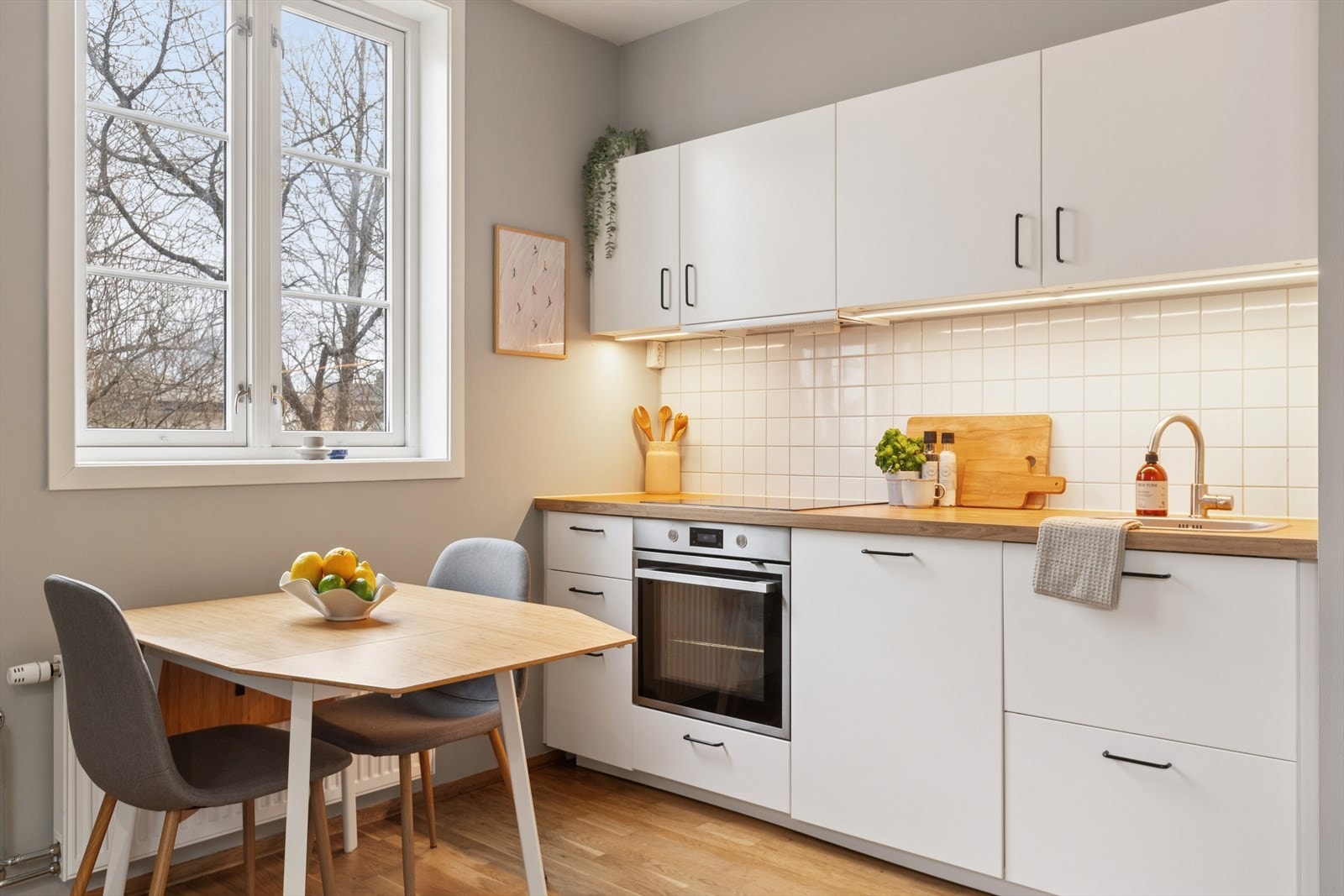 Kjøkkenet har integrerte hvitevarer med montert komfyr, koketopp og oppvaskmaskin Galleribilde