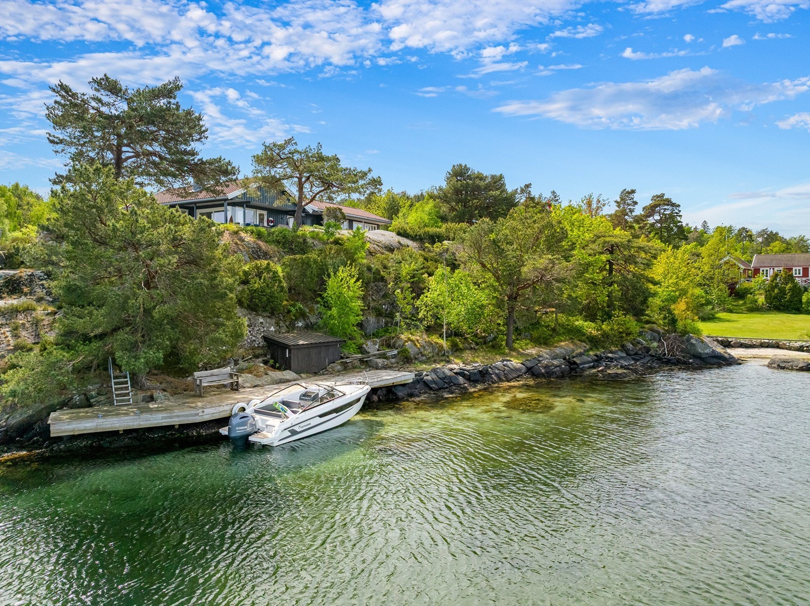 Langstrakt strandlinje med egen sti opp til eiendommen. Galleribilde