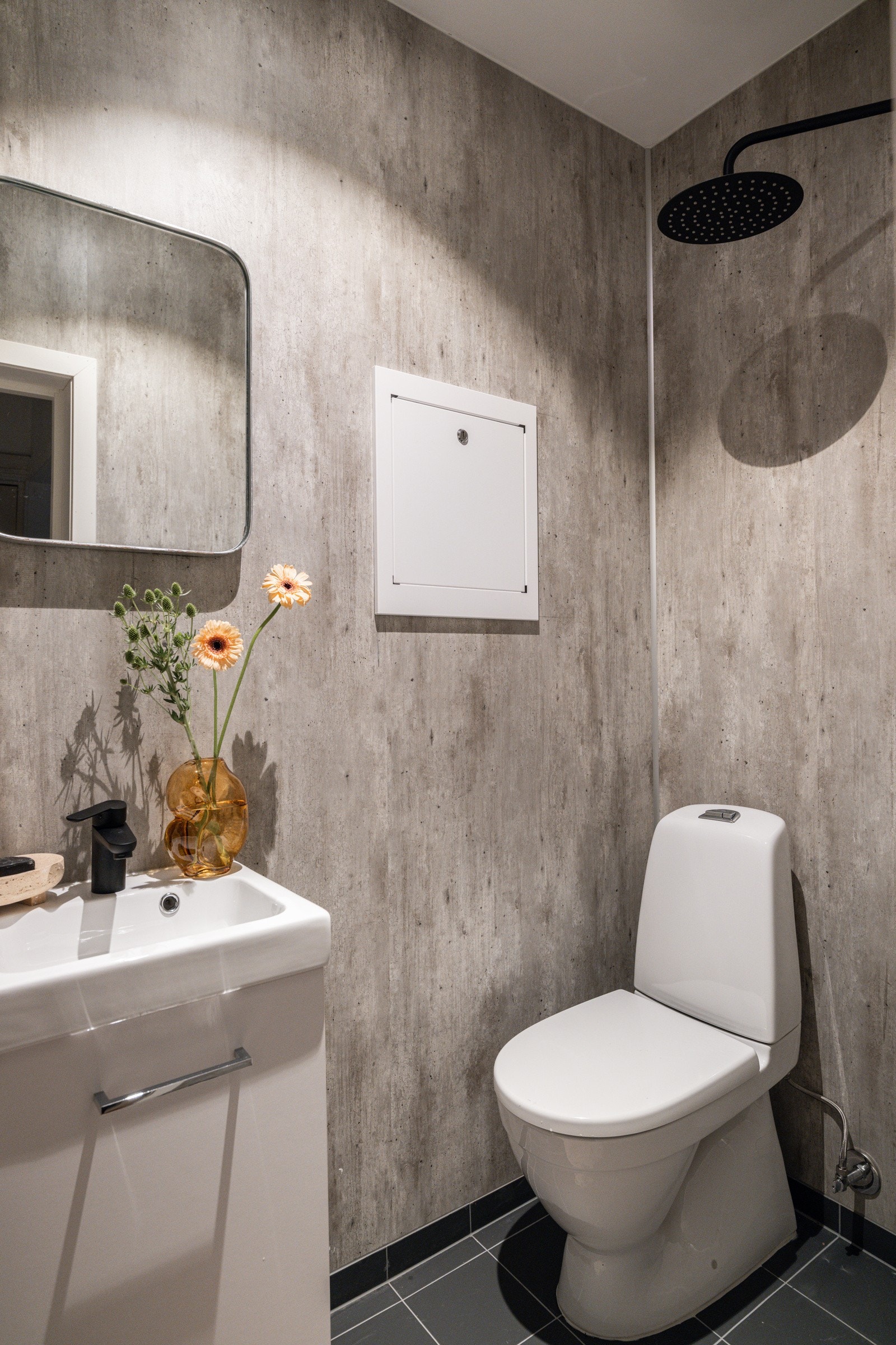 Baderommet er utstyrt med servantskap med speil over, vegghengt armatur med både hånd- og regnfallsdusj og gulvstående toalett. Galleribilde