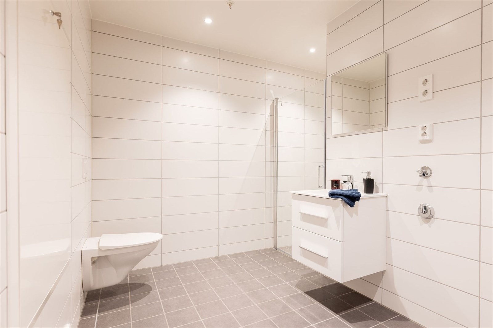 Leiligheten har separat bad og wc-rom. Badet har delikate fliser på gulv og vegger, gulvvarme og opplegg for vaskemaskin. Galleribilde