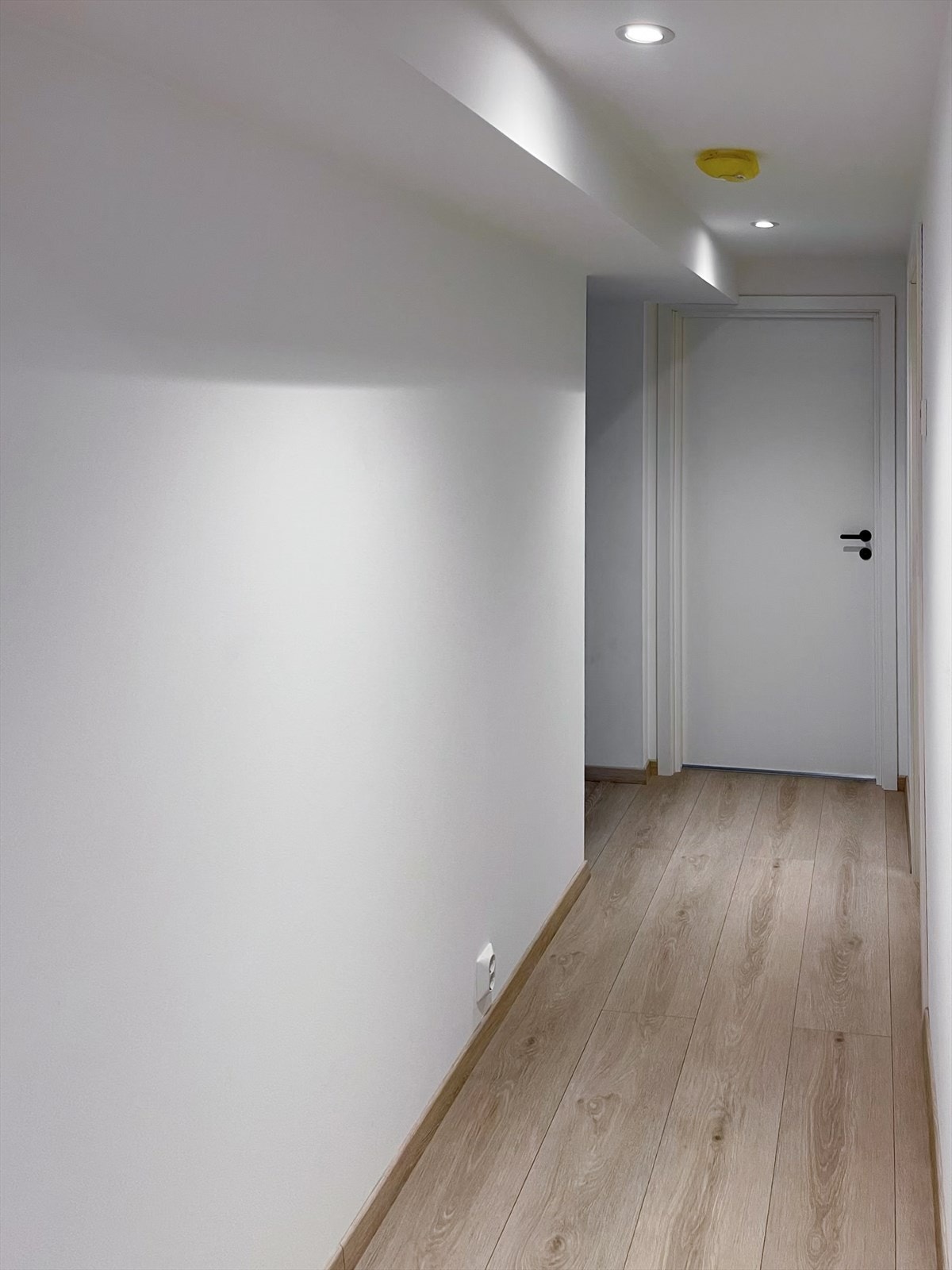 Innbydende gang/entrè med lyse flater, spotter i tak og plass til oppheng av yttertøy. Galleribilde