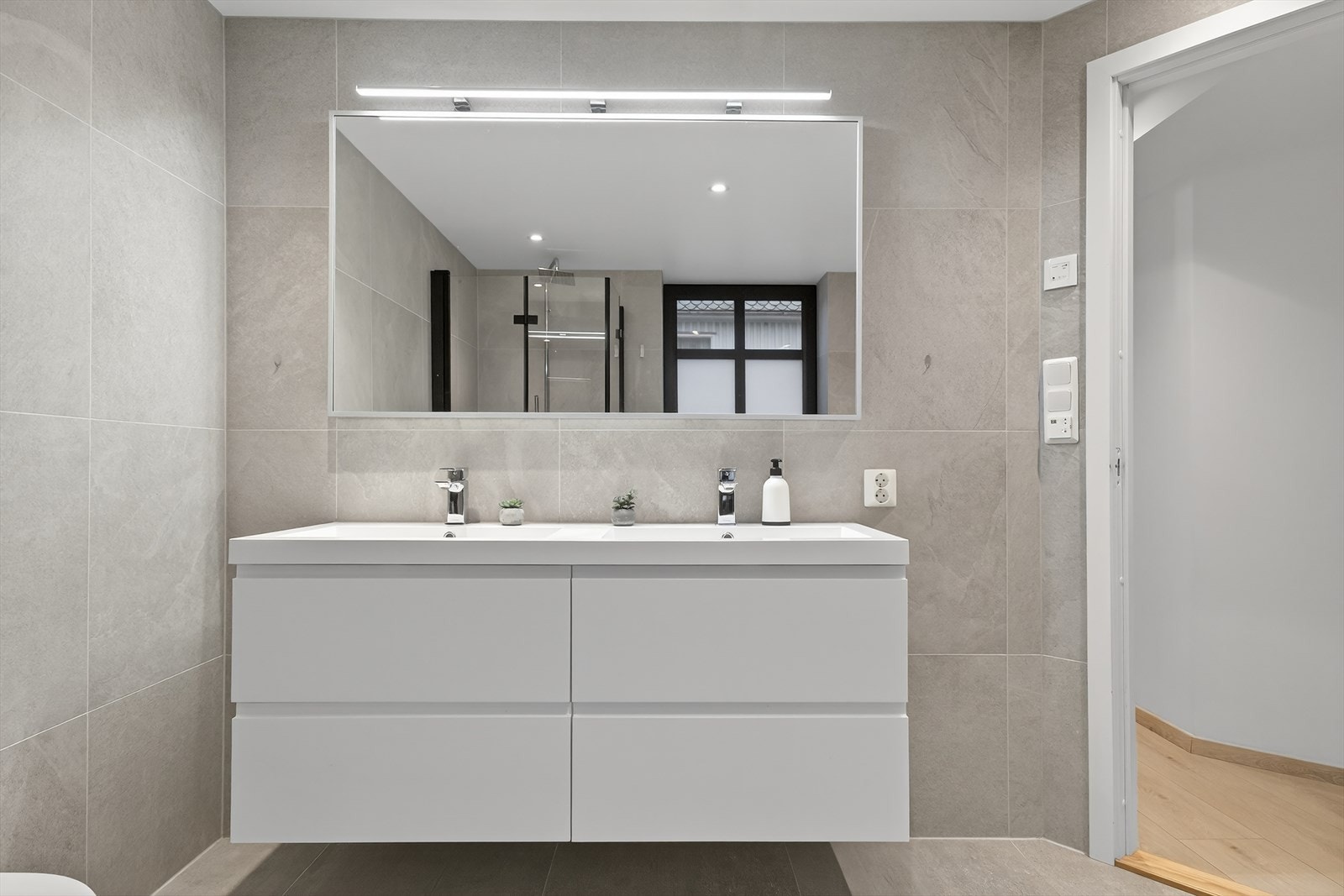 Lekkert, flislagt baderom med moderne innredning. Galleribilde