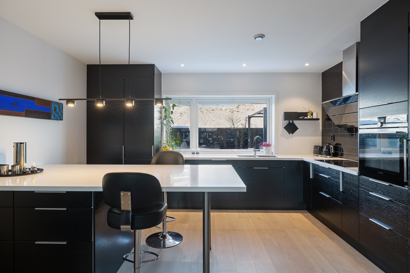 Kjøkkenet har en moderne innredning med glatte fronter og en praktisk kjøkkenøy. Galleribilde