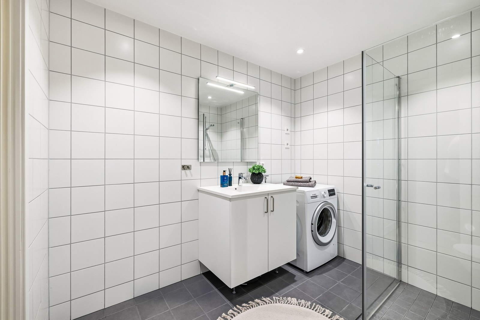 Her er det flislagte overflater, servantinnredning og elektriske varmekabler i gulvet. Galleribilde