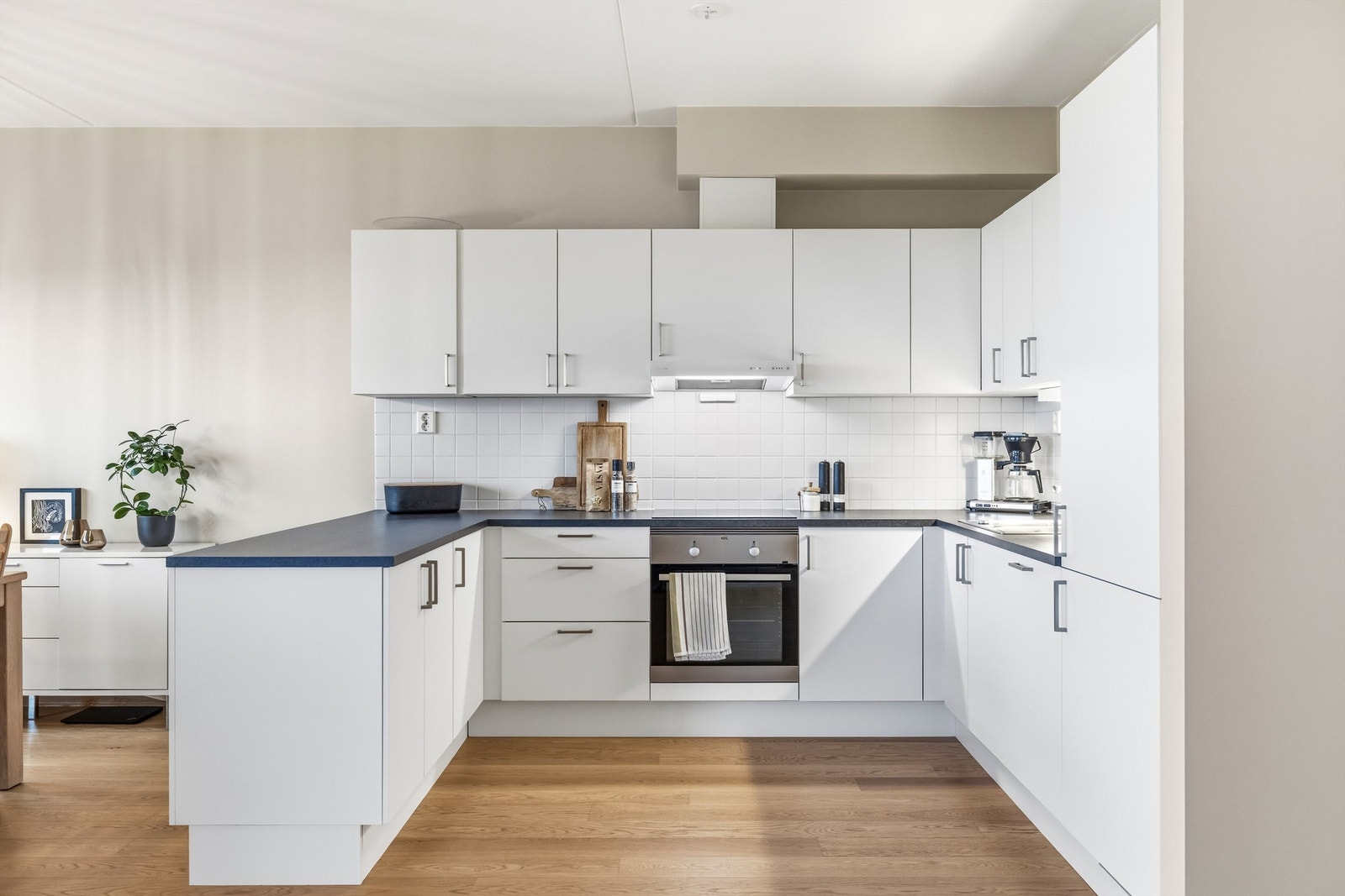 Kjøkkeninnredningen har glatte, hvite fronter og en slitesterk benkeplate i laminat. Galleribilde