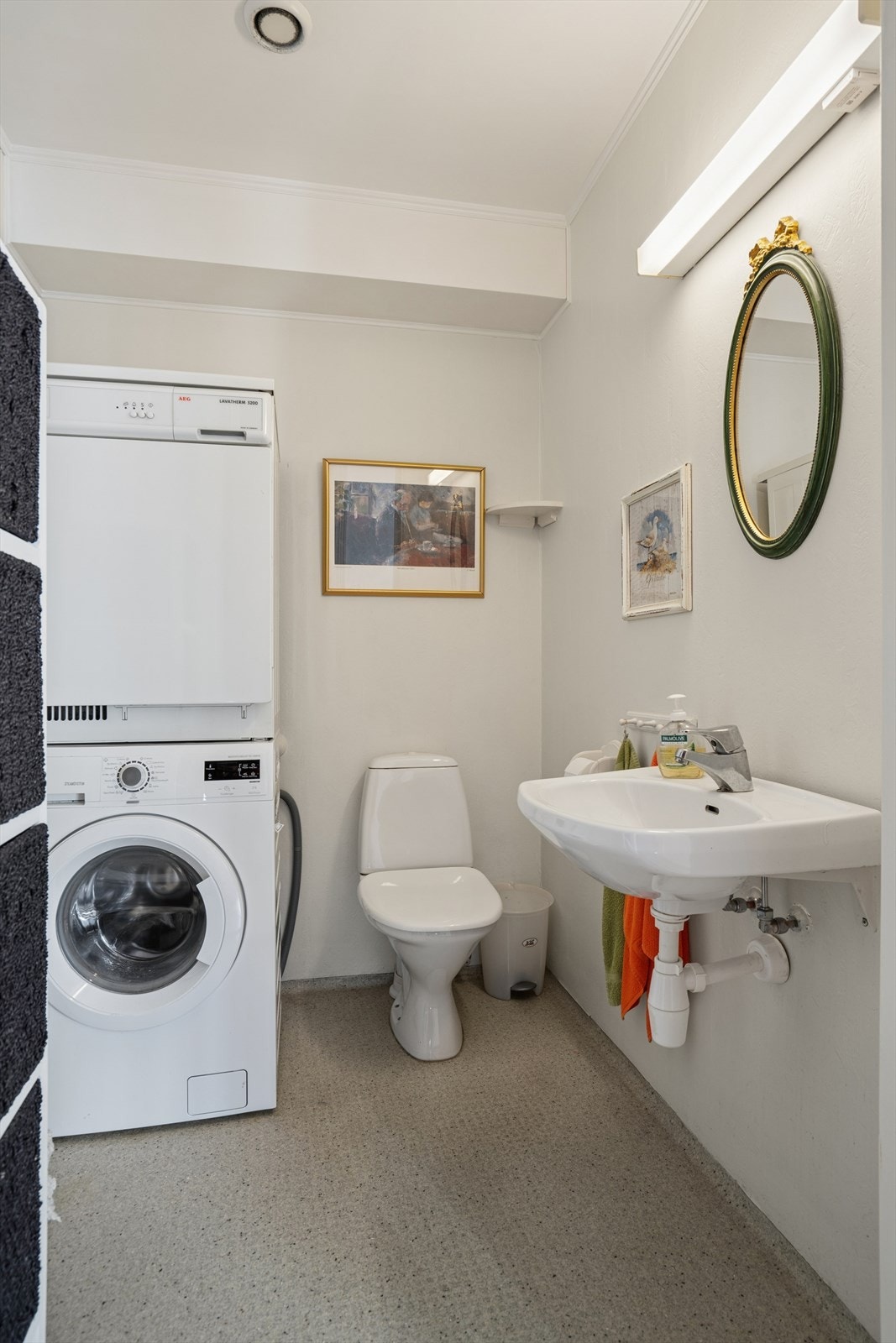 Toalettrom/vaskerom med vinylbelegg på gulv og malte vegger - Her finner du toalett, servant, opplegg for vaskemaskin og stråleovn til oppvarming Galleribilde