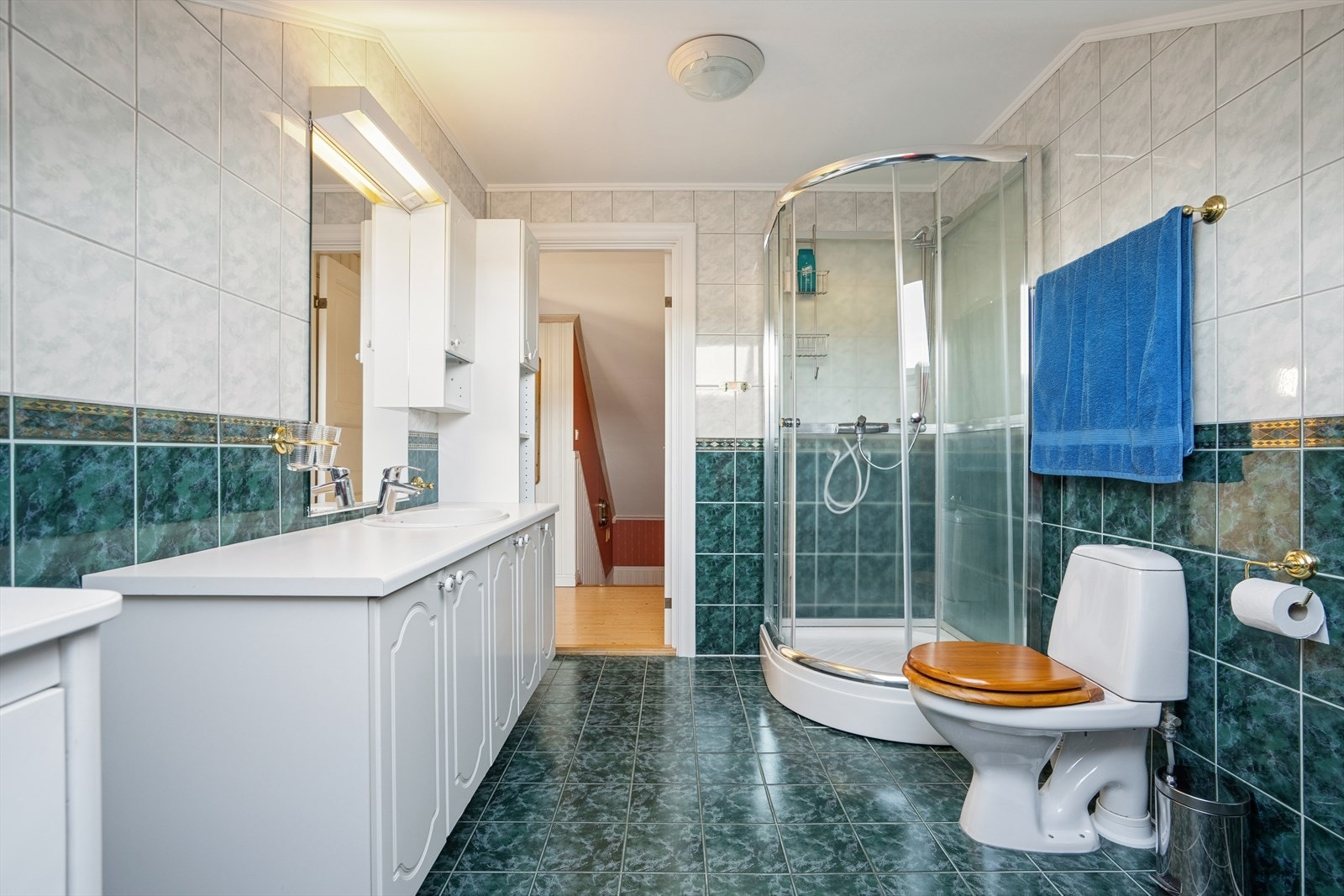 Badet er utført med flislagte overflater og har oppvarming med elektriske varmekabler - Her finner du toalett, dusjkabinett og baderomsinnredning Galleribilde