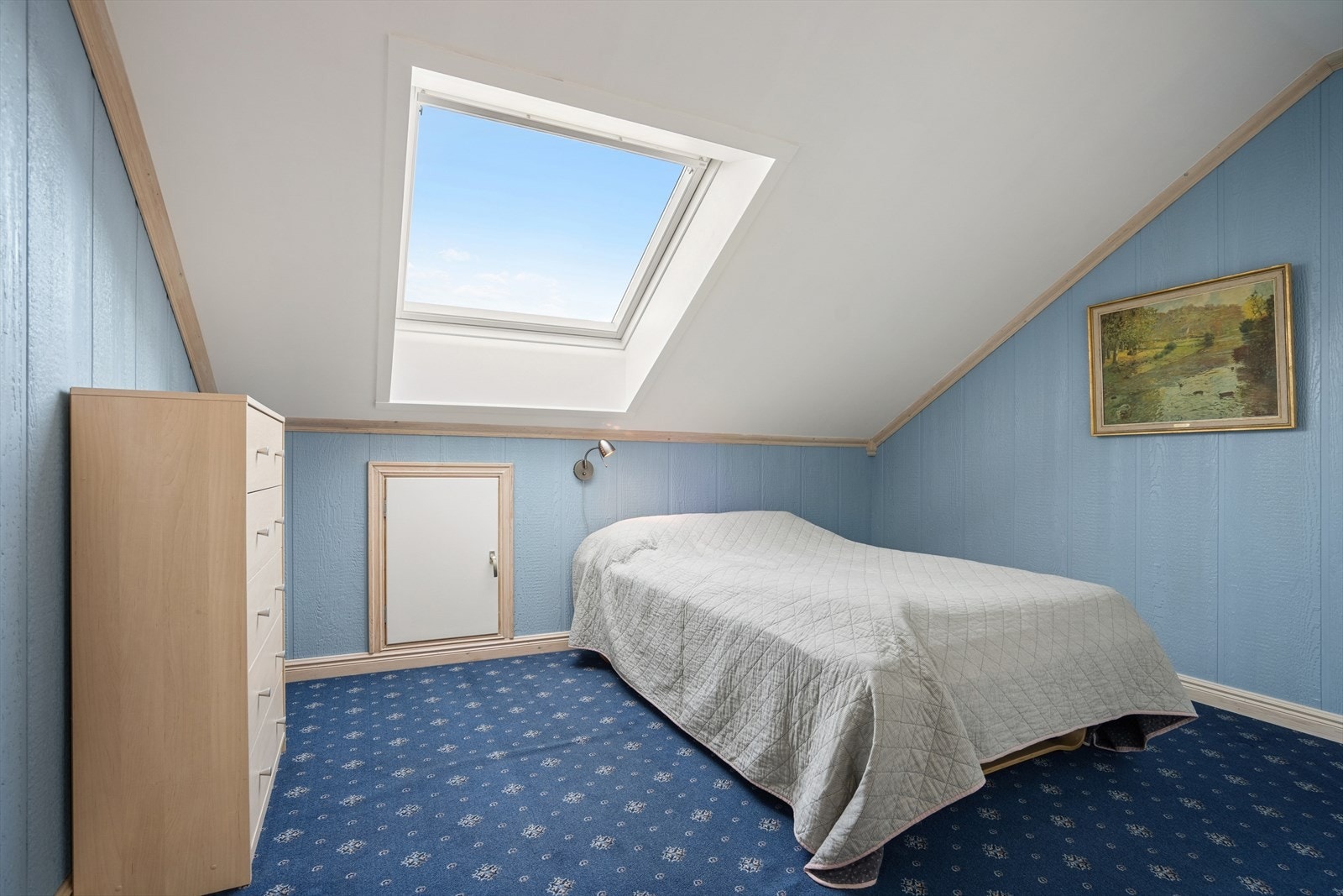 Soverom II - Hovedsoverommet er utført med teppegulv, blåmalte veggflater og himling med takvindu - Det er god plass til både dobbeltseng og oppbevaringsløsninger Galleribilde