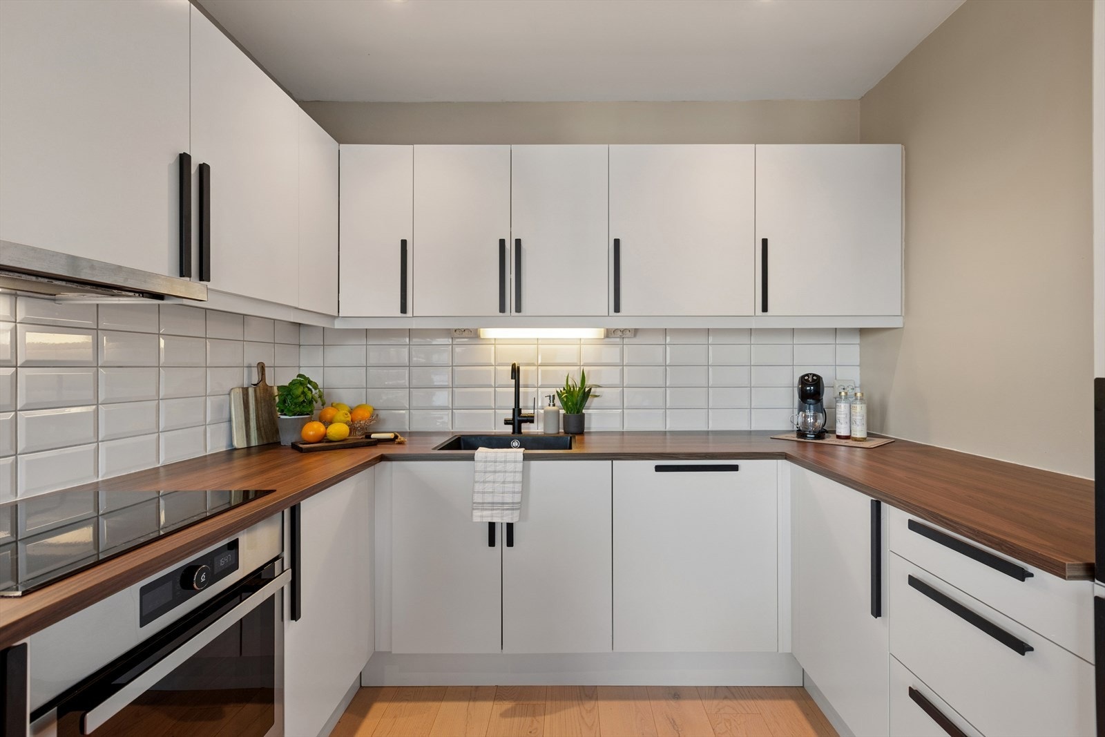 Kjøkkenet er utstyrt med et rikelig utvalg av skap- og skuffeløsninger. Her har man også en stor kjøkkenbenk for forberedelse av både små og store måltider Galleribilde