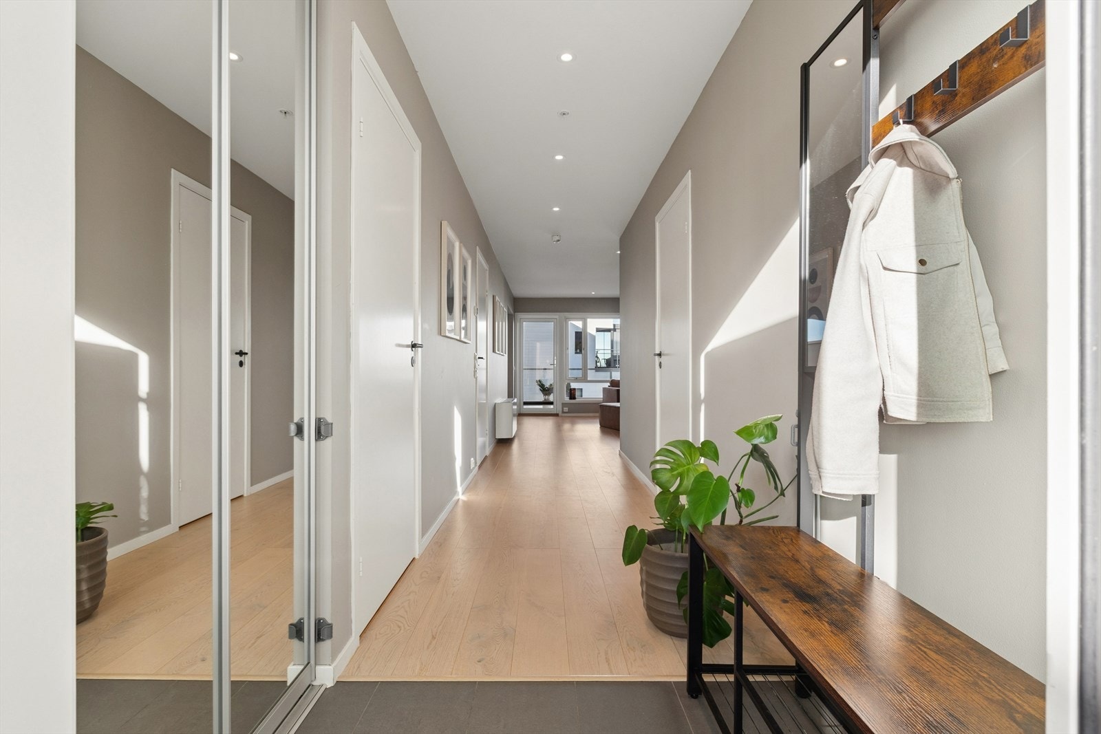 Entréen er flislagt og har montert garderobeløsning med speilfronter Galleribilde