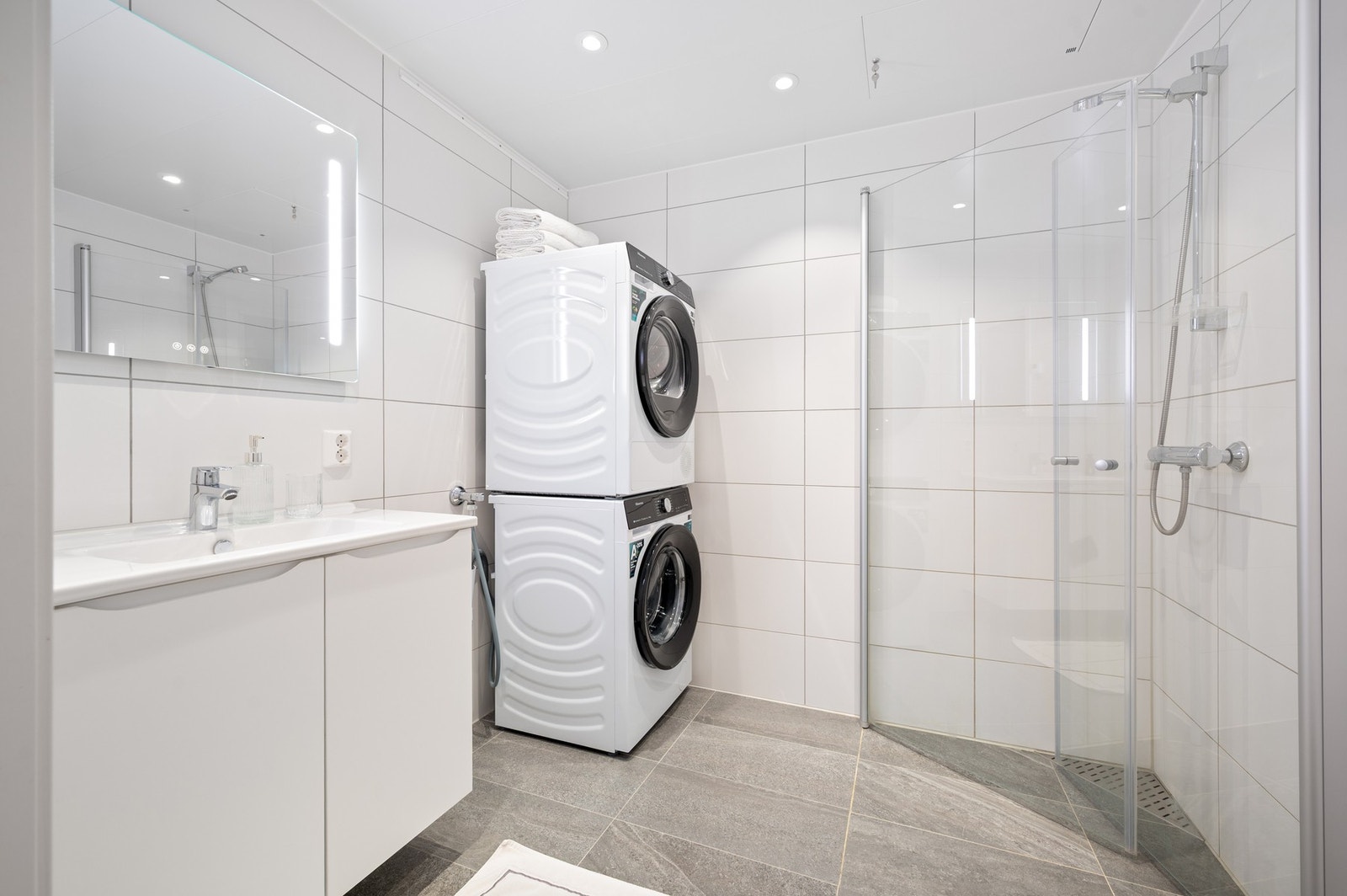 Lekkert flislagt bad på 4,5 m² med opplegg for vaskemaskin. Vannbåren varme i gulv. Galleribilde