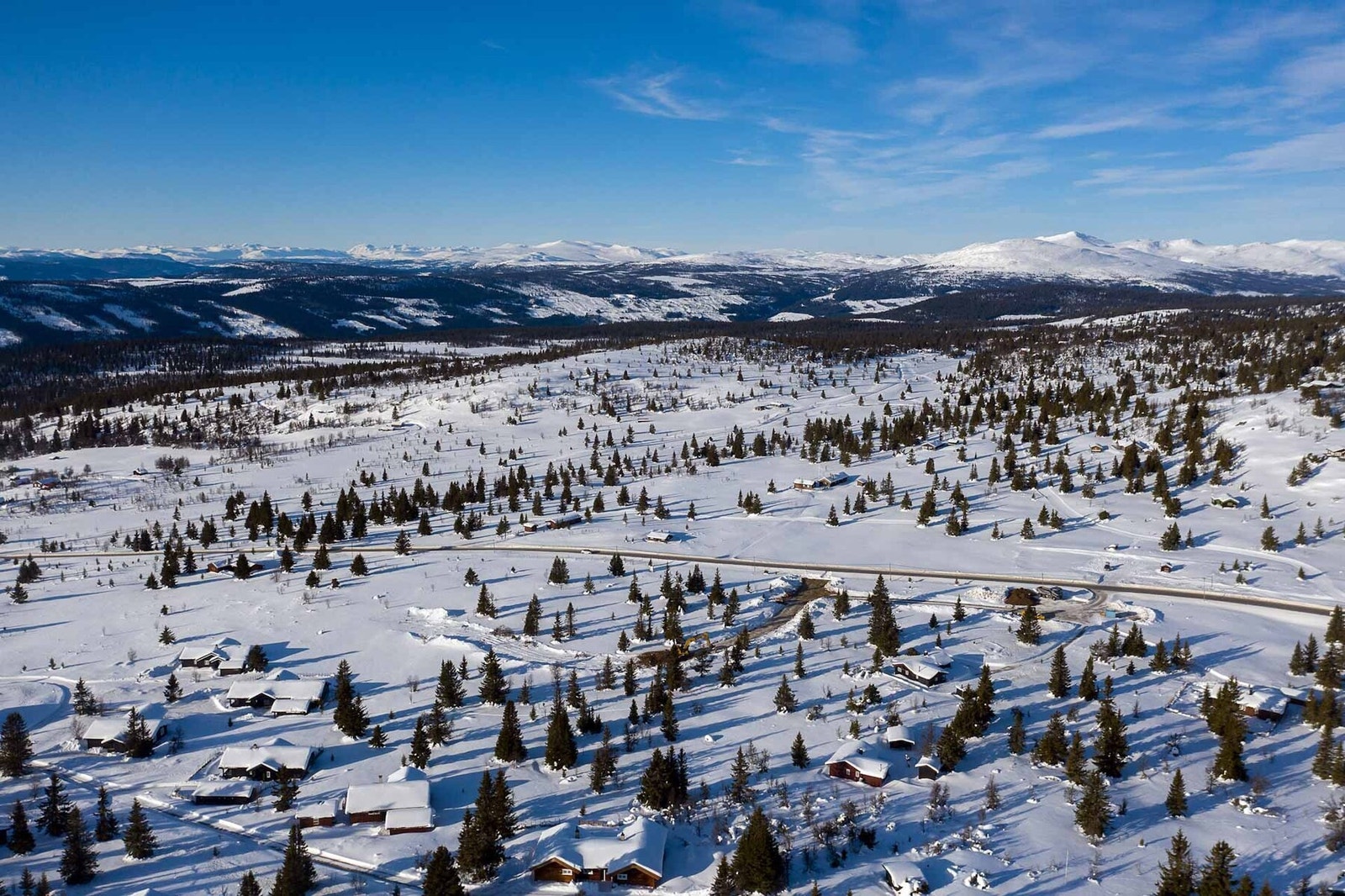 Dronefoto over tomtene mot nordvest. Flere av tindene i Jotunheimen ses i det fjerne Galleribilde