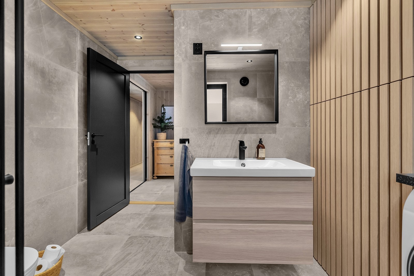 Bad/vaskerom med store fliser på både vegger og gulv Galleribilde