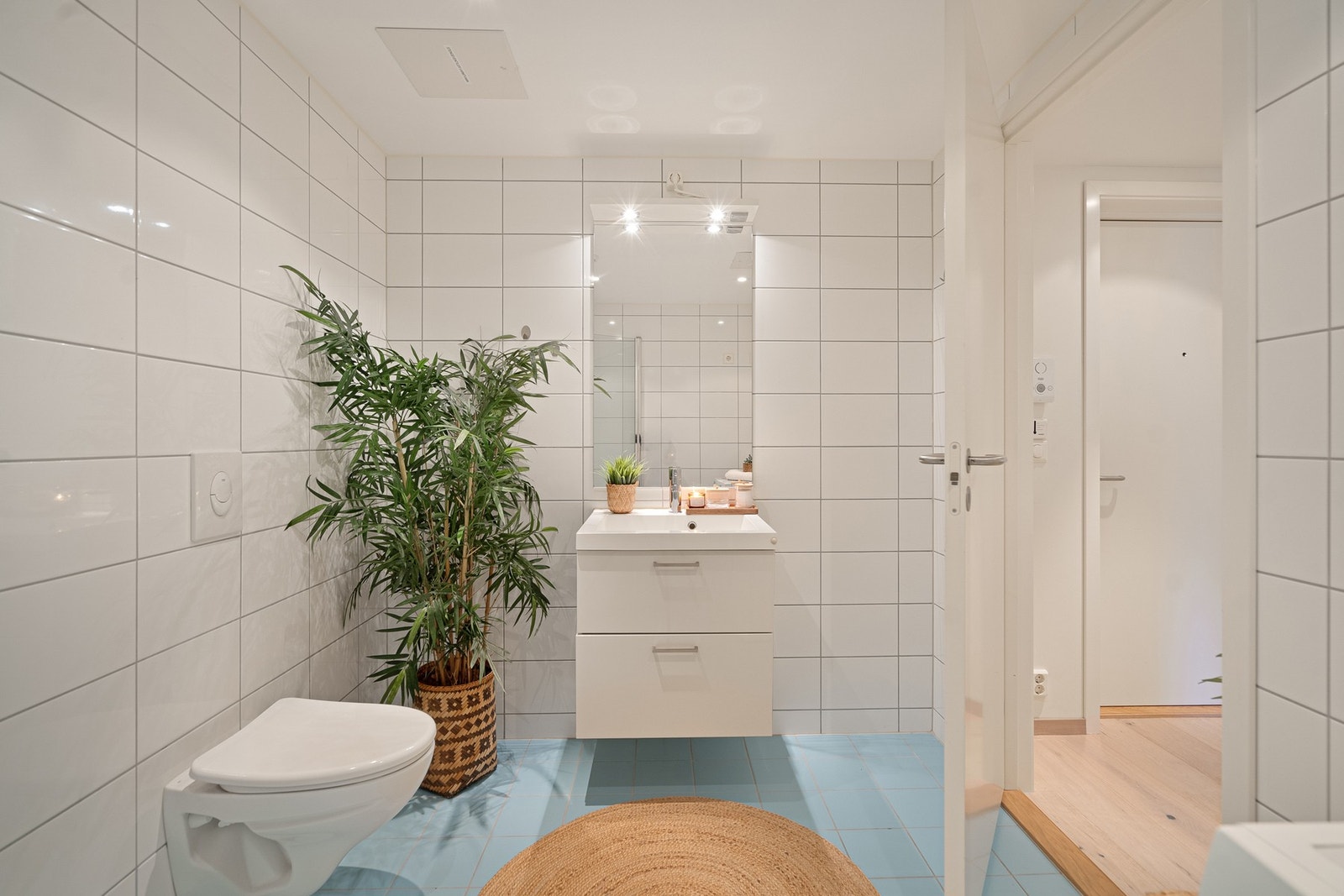 Badet er flislagt med delikate fliser på både gulv og vegger, og byr på moderne baderomsinnredning, vegghengt toalett, speilskap og komfortable varmekabler i gulvet. Galleribilde